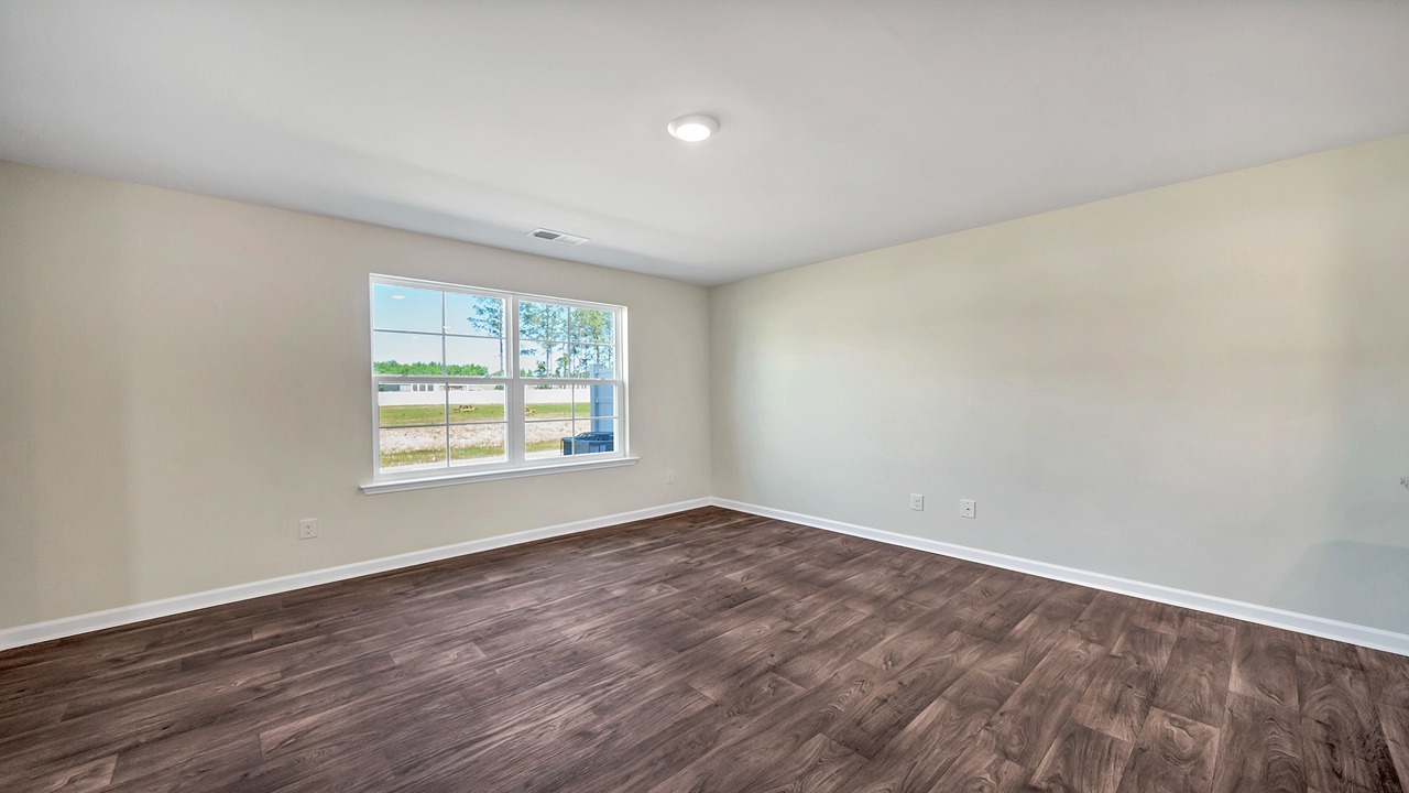 The living area is spacious with a large window and vinyl floors.