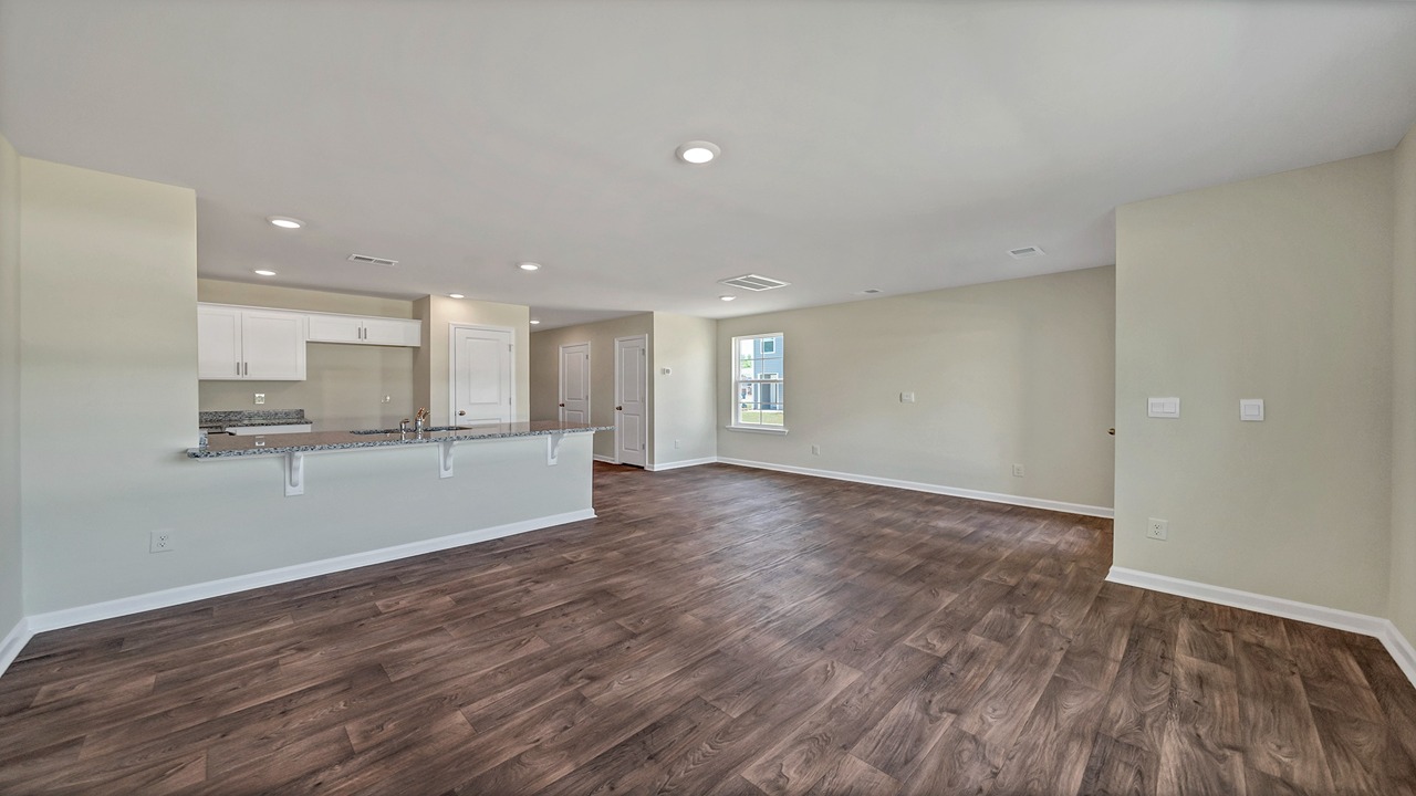 The kitchen, dining, and living areas are open and are finished with modern vinyl flooring.
