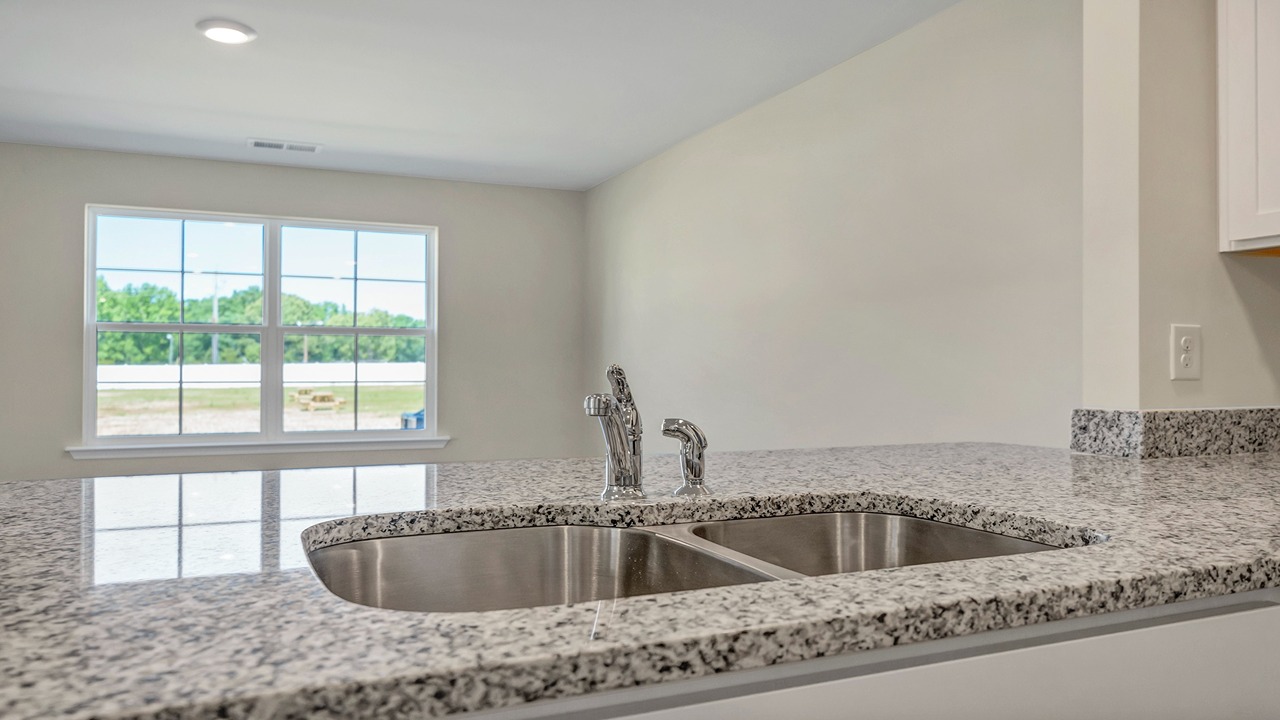 The kitchen sink is on the bar and overlooks the living area.