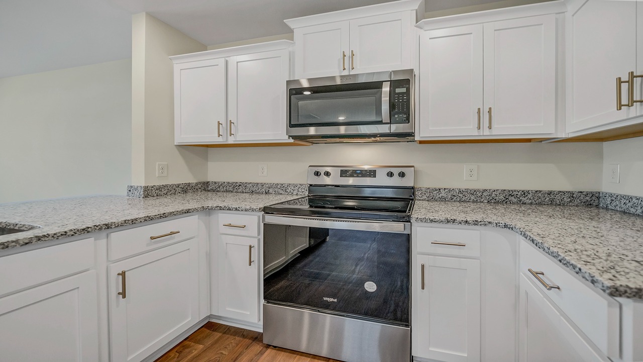 The microwave is located over the stainless steel stove.