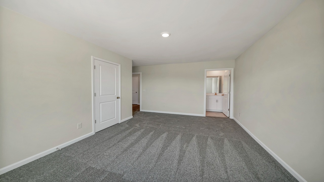 The primary bedroom is spacious with a large window and a private walk-in closet.