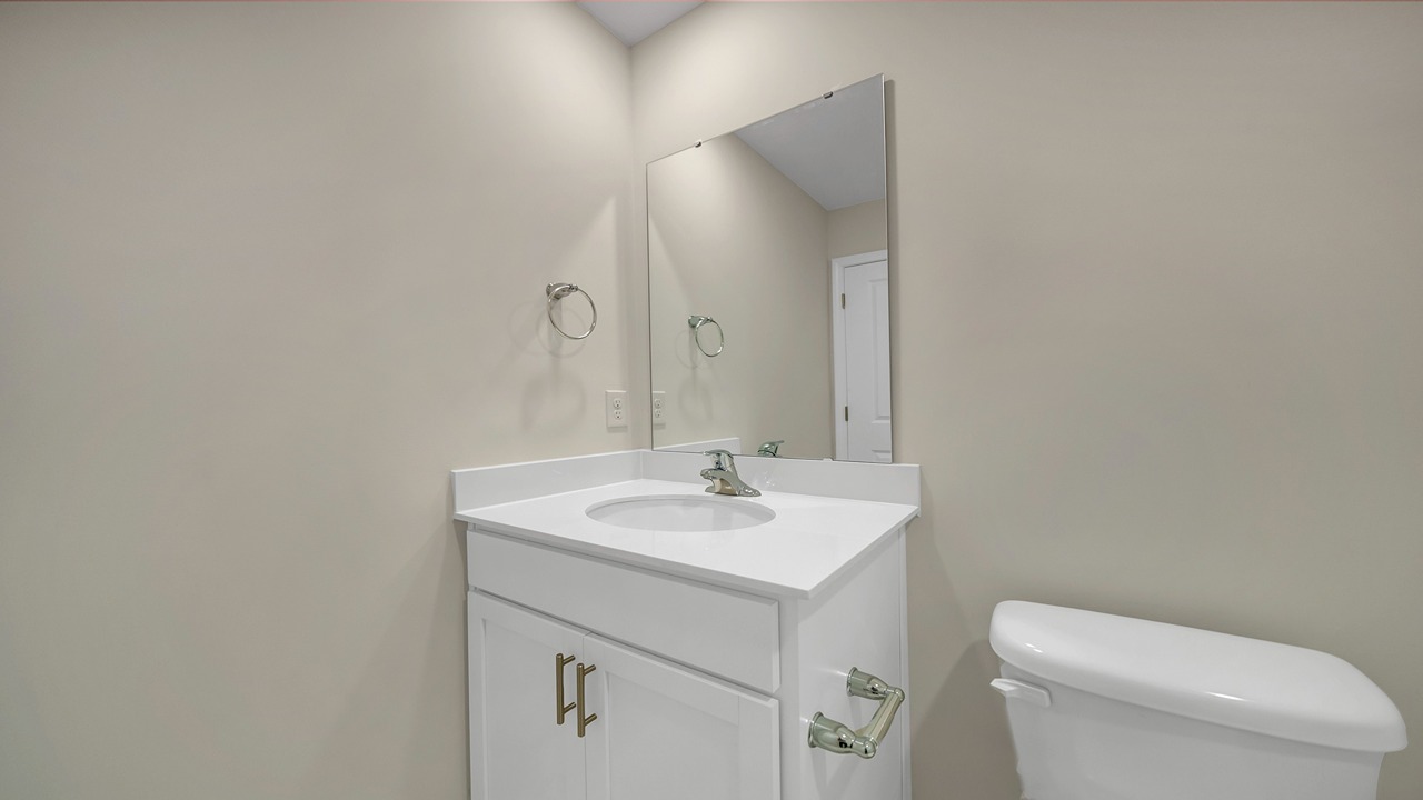 Bathroom 2 upstairs features a shower/tub combo and white cabinetry.