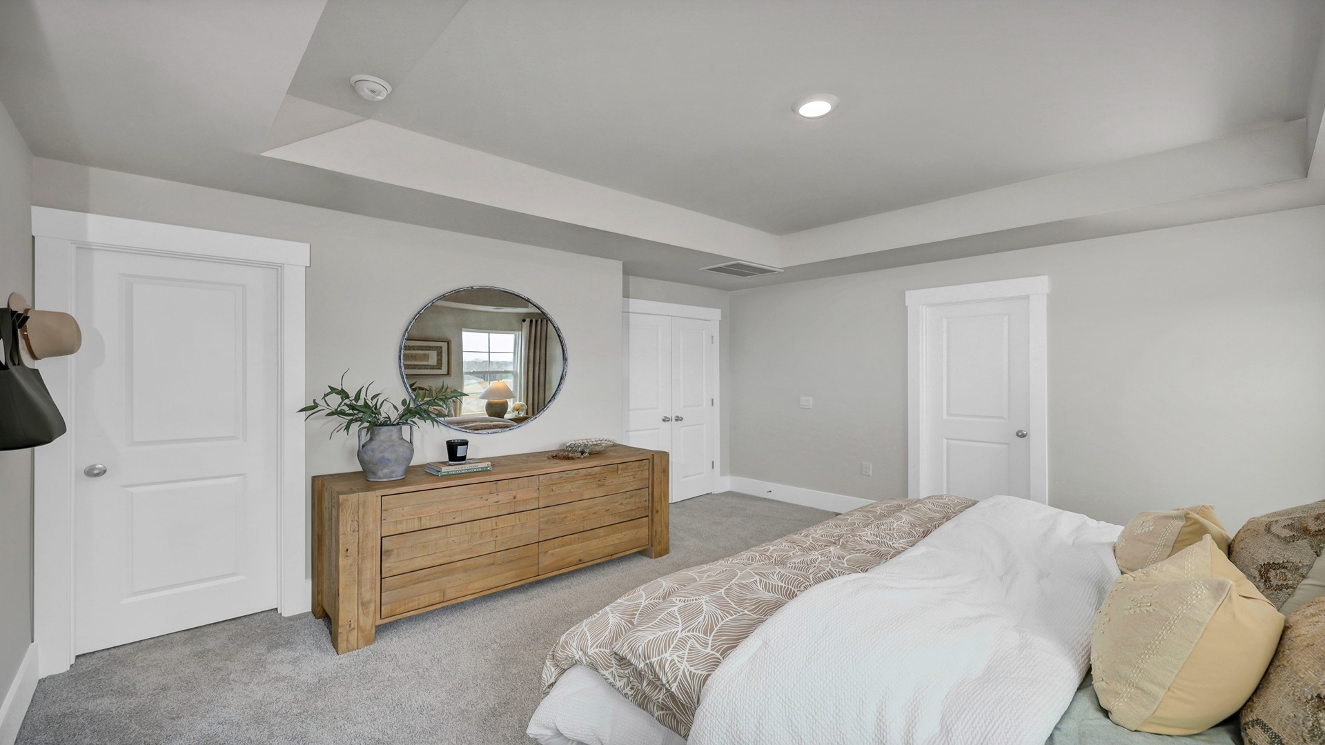 Primary bedroom upstairs with carpet flooring and tray ceilings