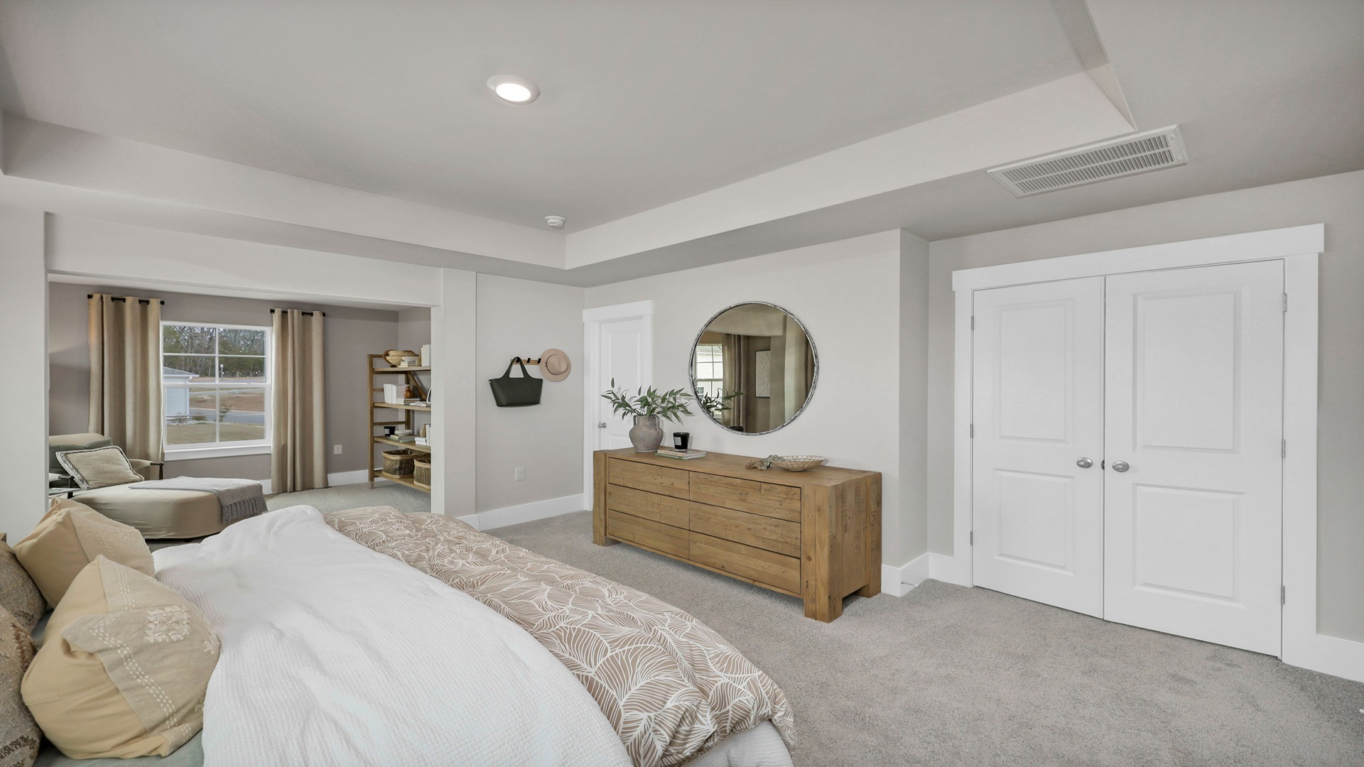 Primary bedroom upstairs with carpet flooring and tray ceilings