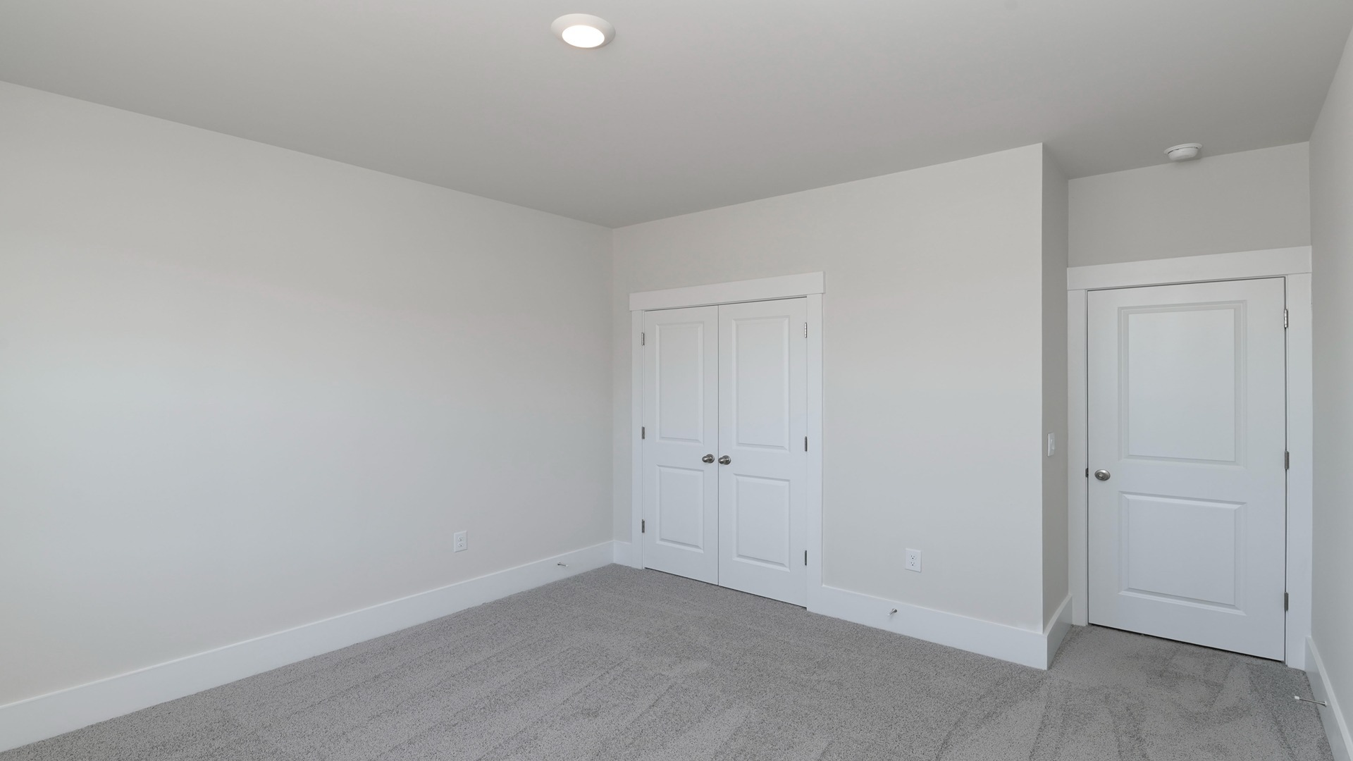 Carpet flooring and French closet doors in bedroom 2