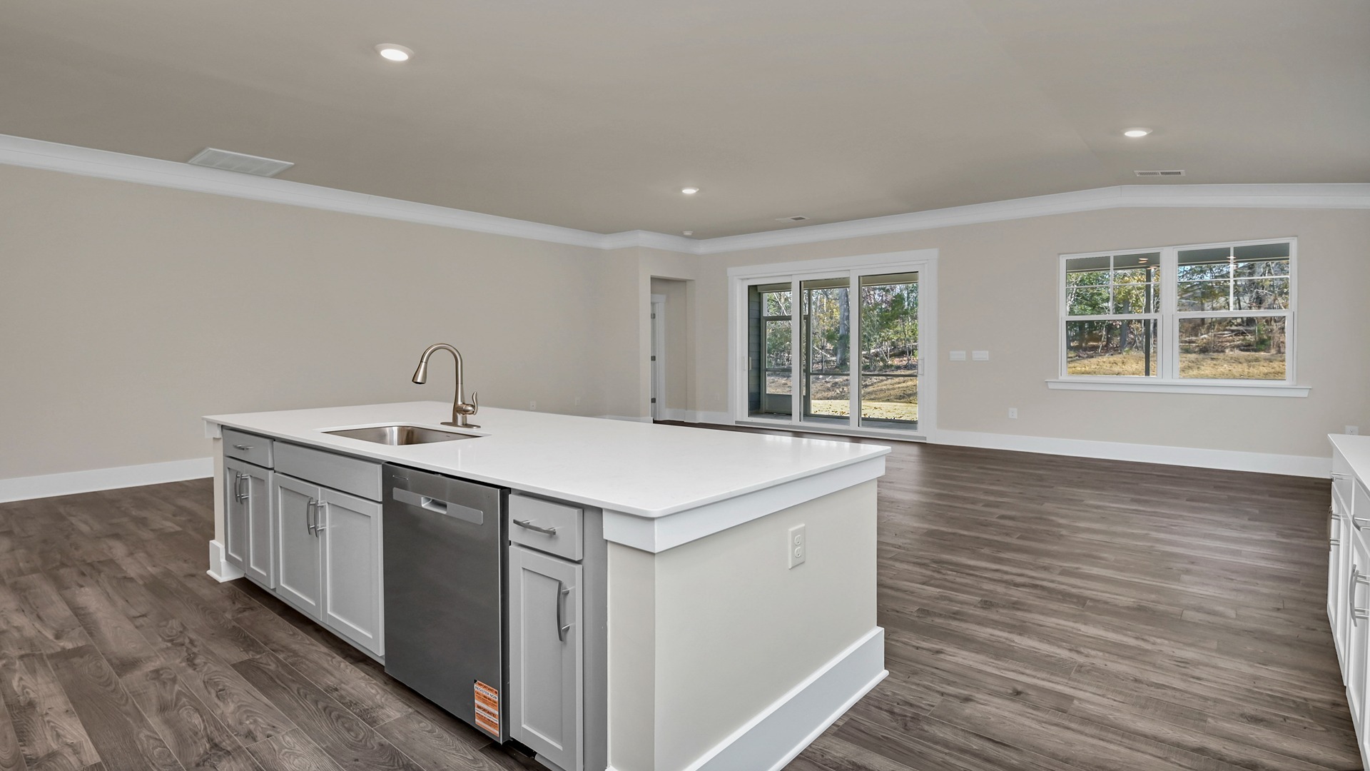 Floating island in new construction single-story home overlooks dining and living areas