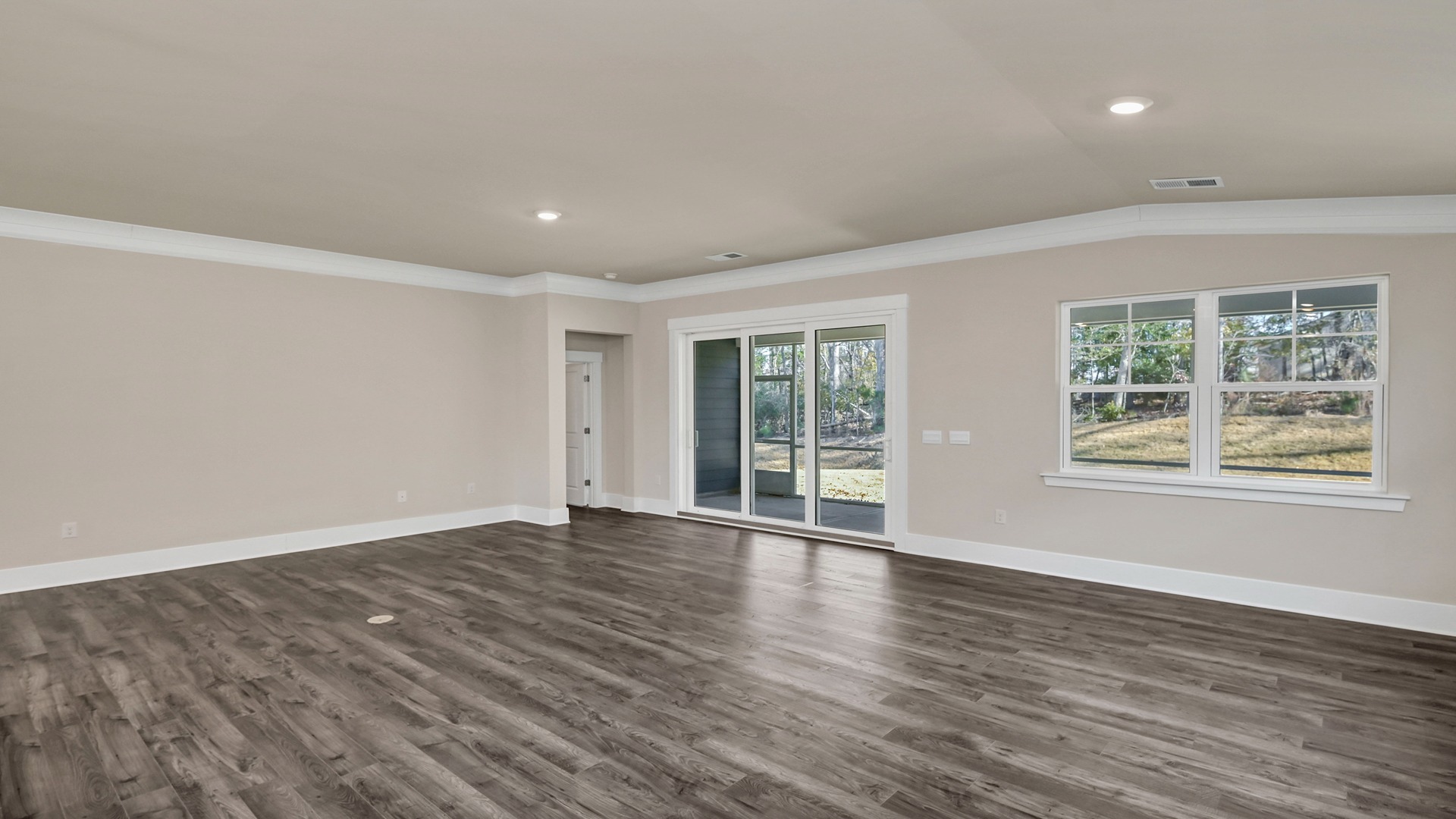 Dining and living areas with several windows and sliding back doors