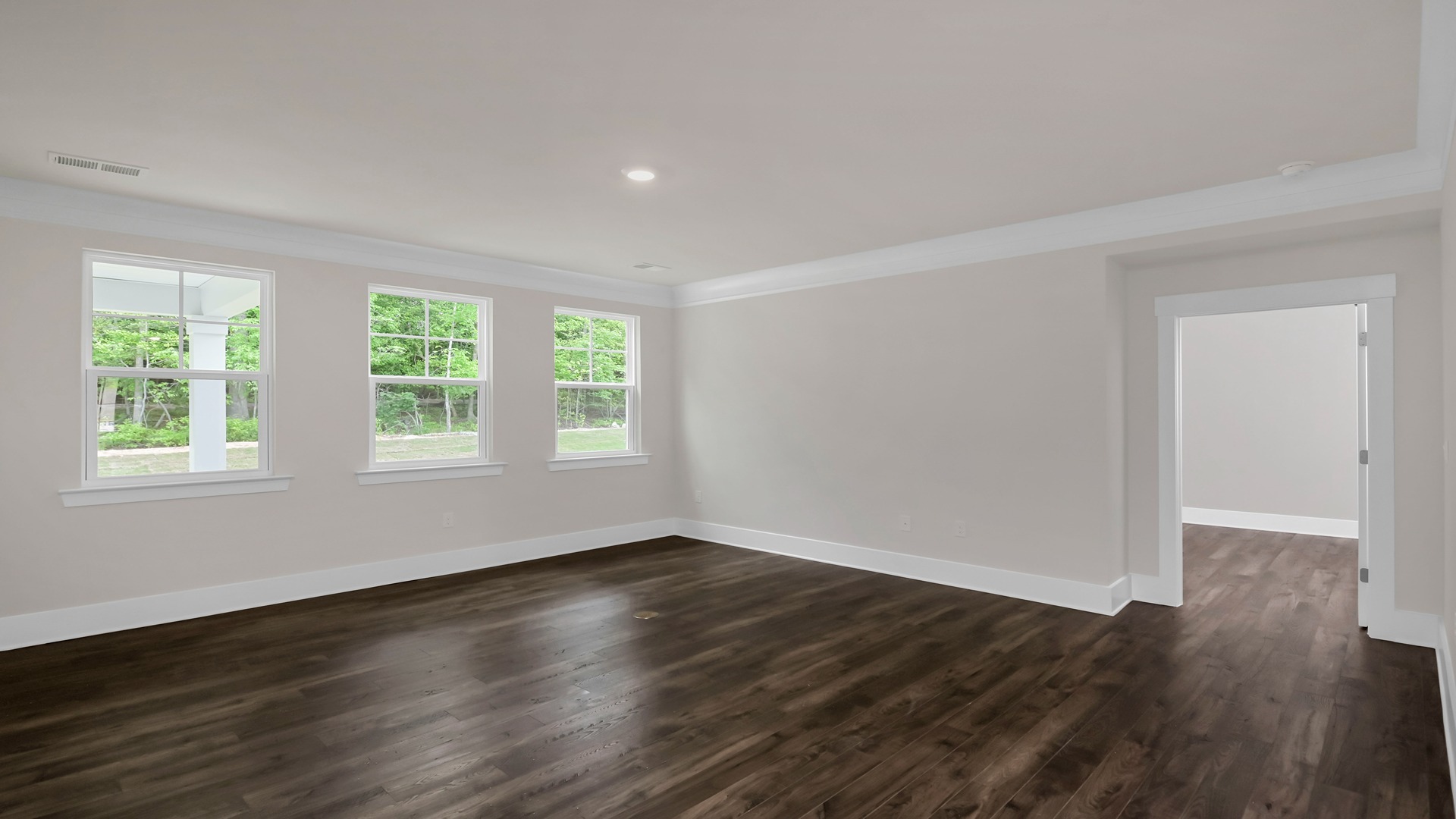 Spacious, open living area leads into the private primary suite at the back of the home