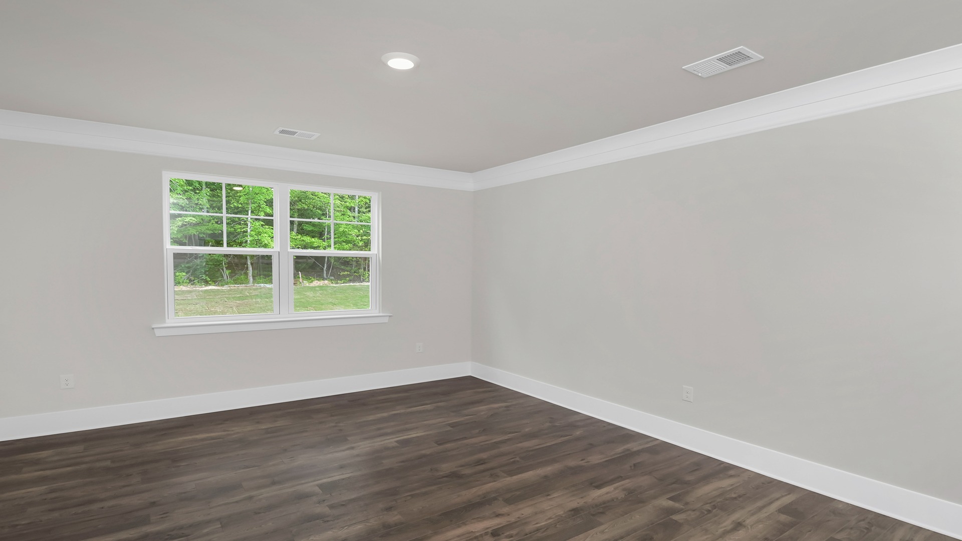 Private primary bedroom tucked into the back of the home with RevWood flooring