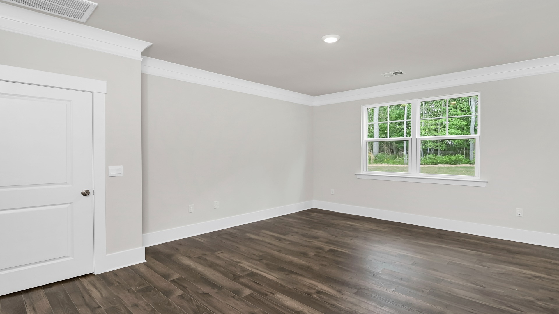 Primary bedroom with natural light and RevWood flooring