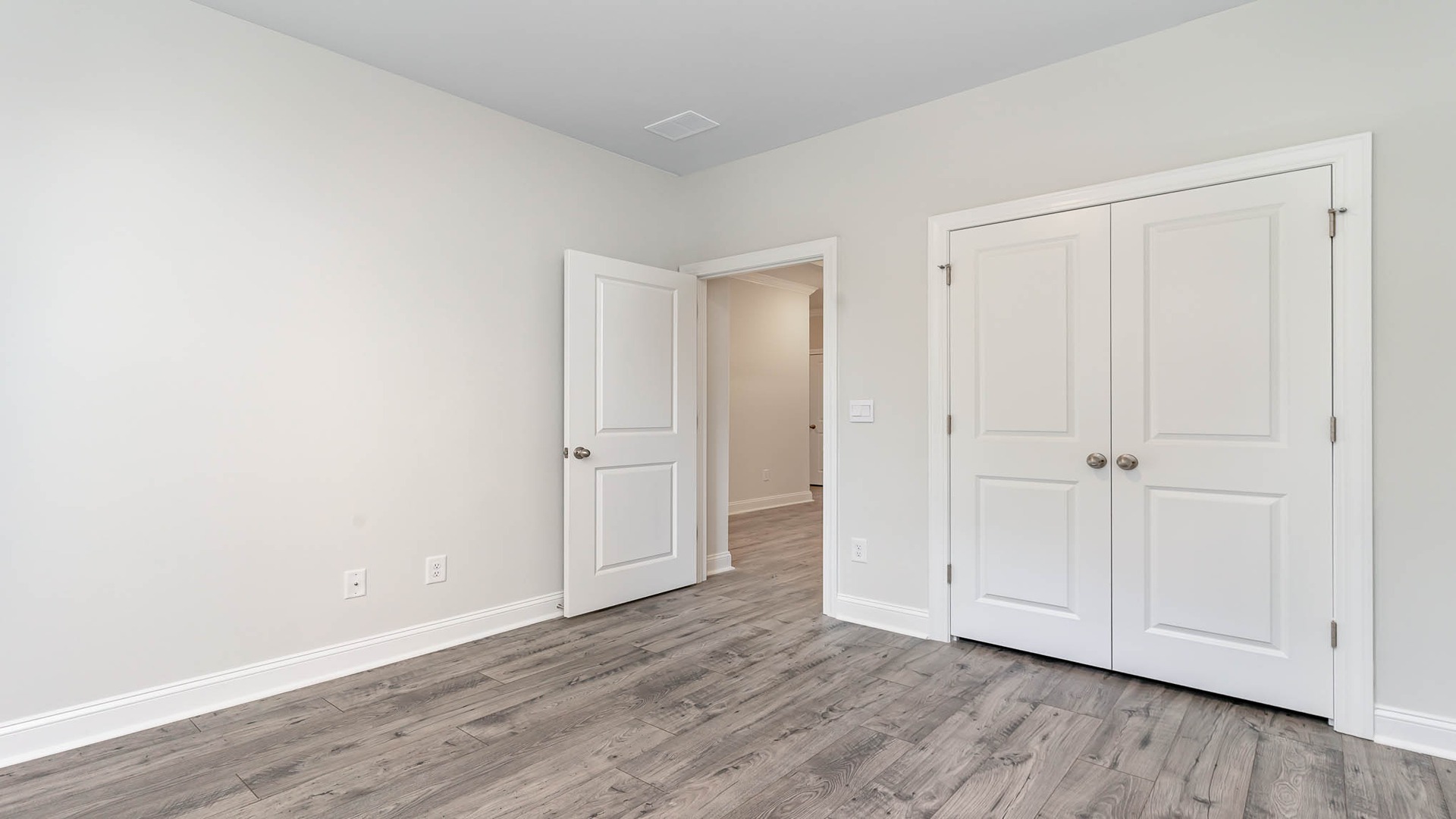 Bedroom 2 with French closet doors in new construction home for sale in Lake Tide Summit