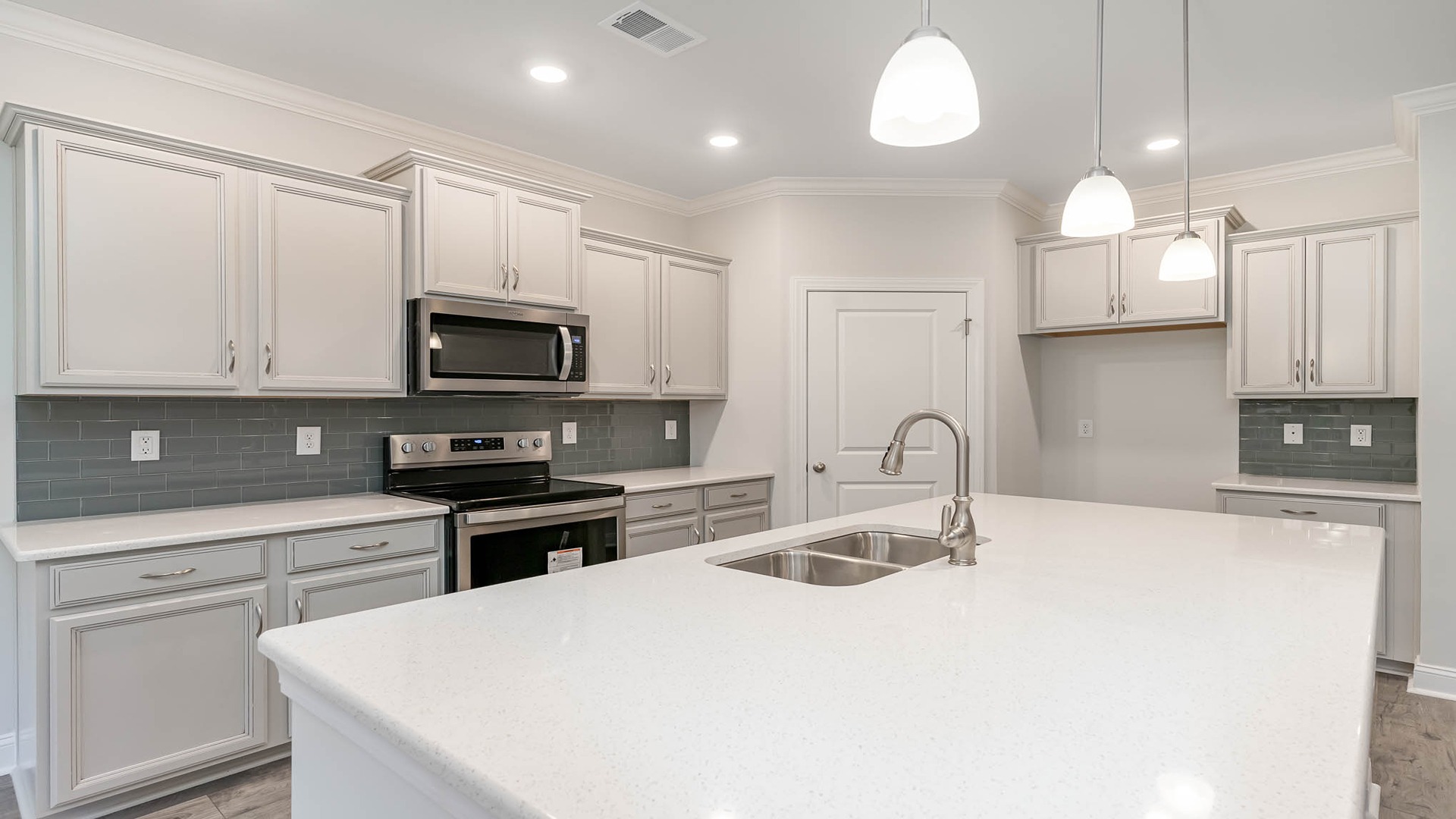 Tile backsplash and a spacious walk-in corner pantry in the kitchen
