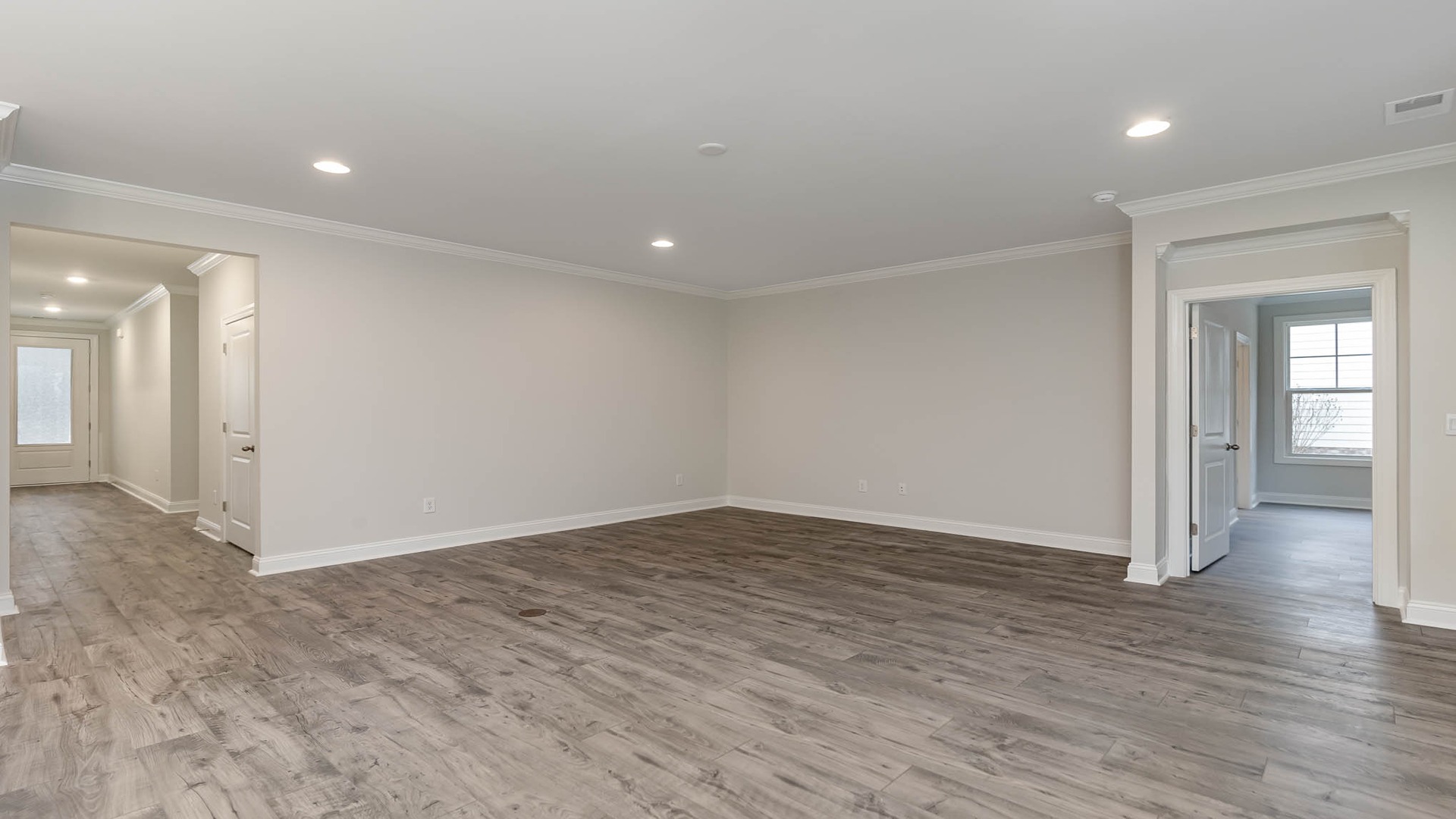 Revwood flooring finishes main living areas and the living area leads into the primary suite