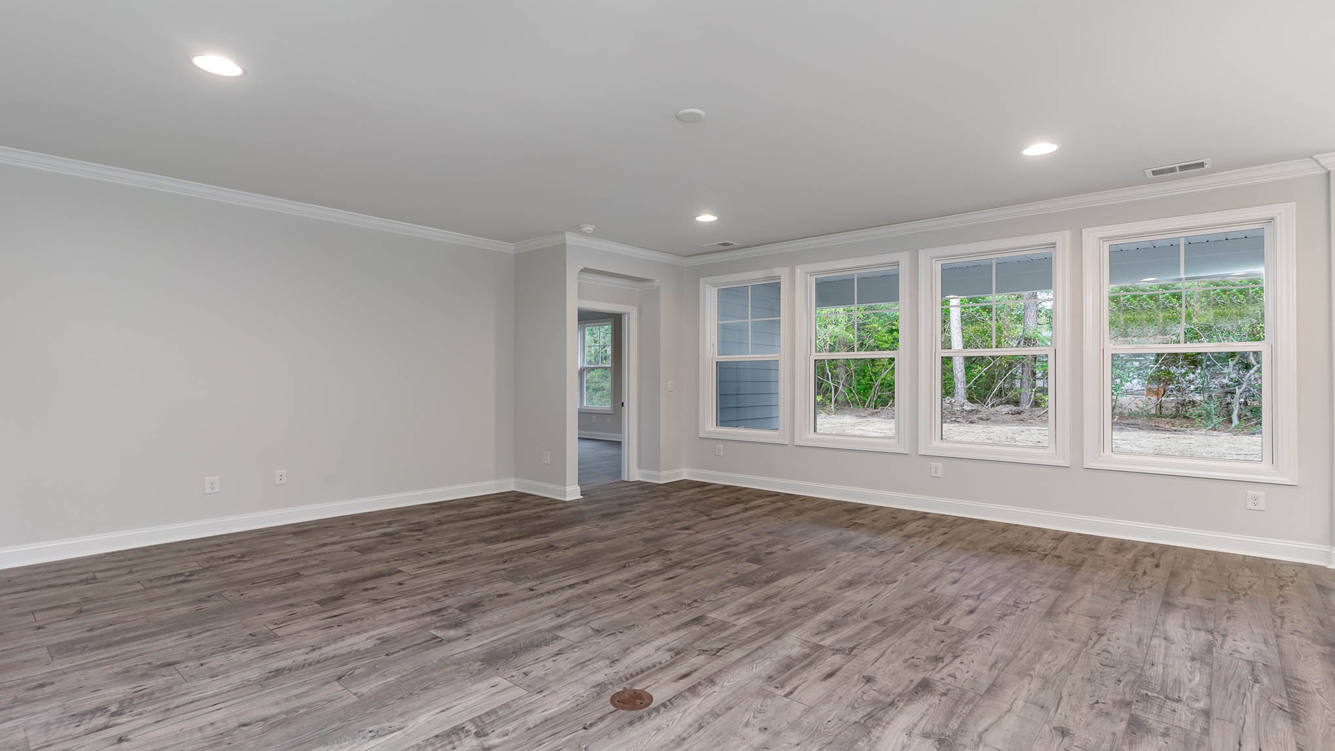 Very large living area in new construction home for sale in Chapin with RevWood floors and a wall of windows for natural light