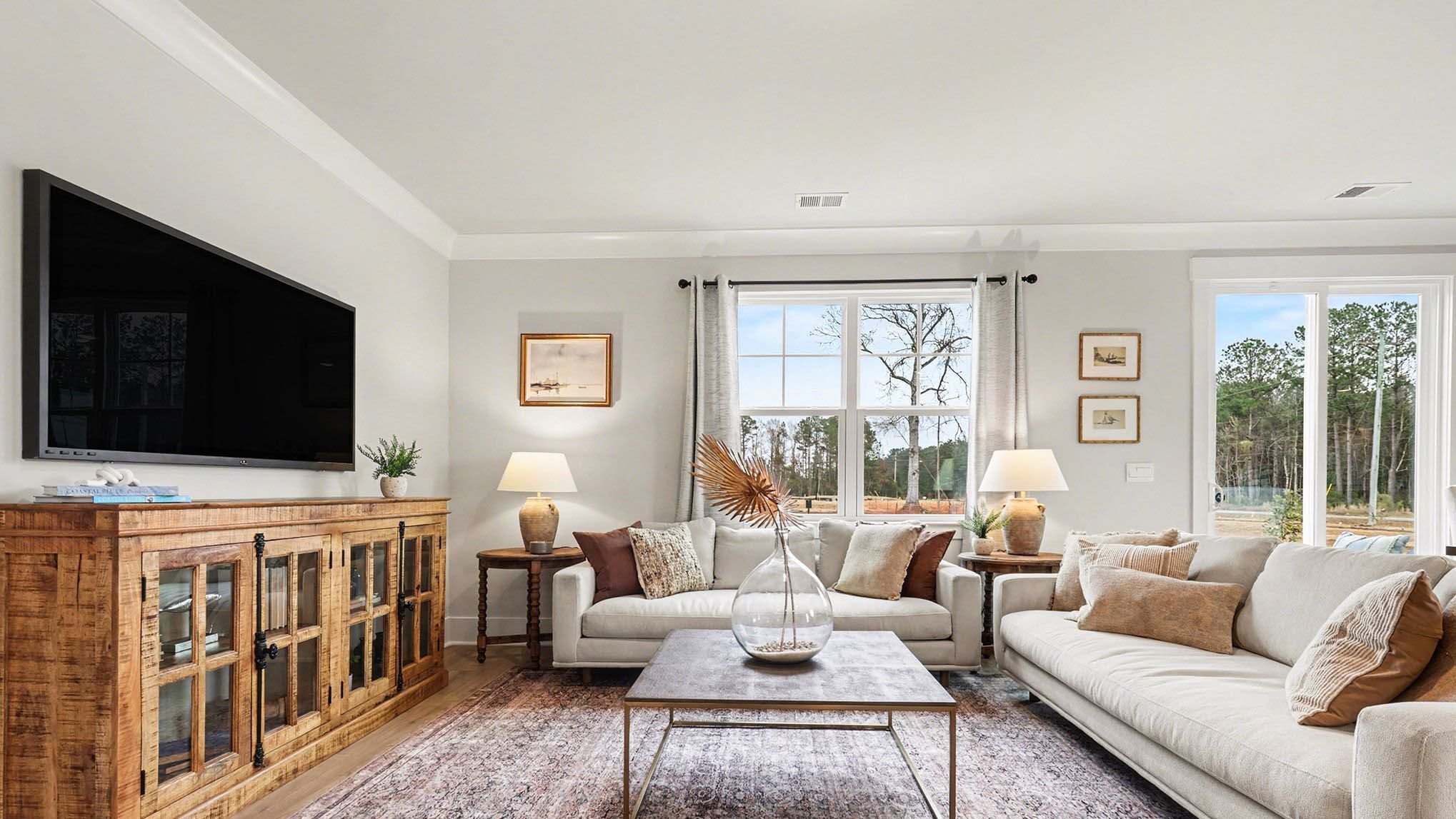 Living area in new construction home with windows for natural light and RevWood flooring