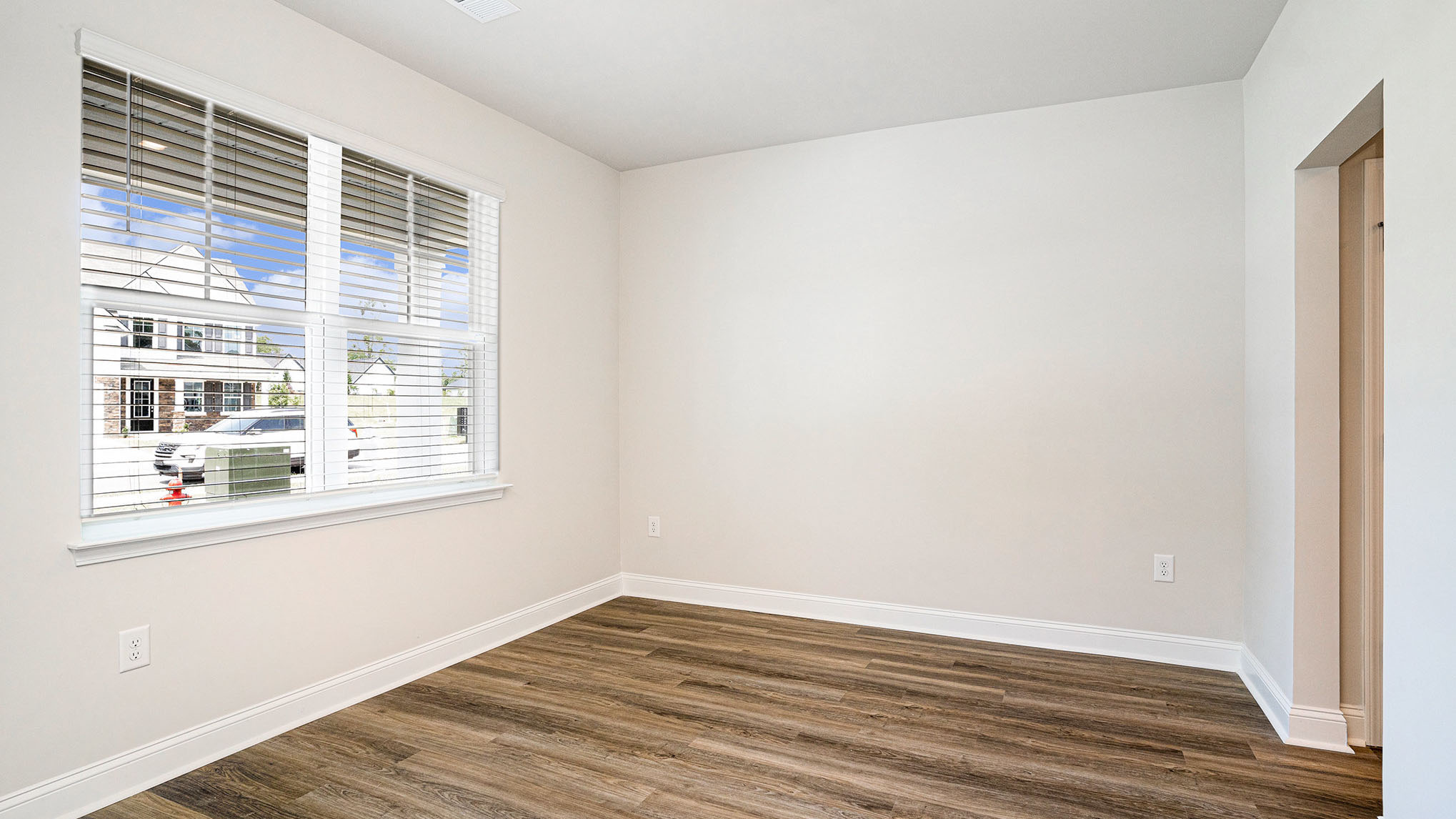 Dining area at the front of the home with RevWood flooring and a front facing window for natural light