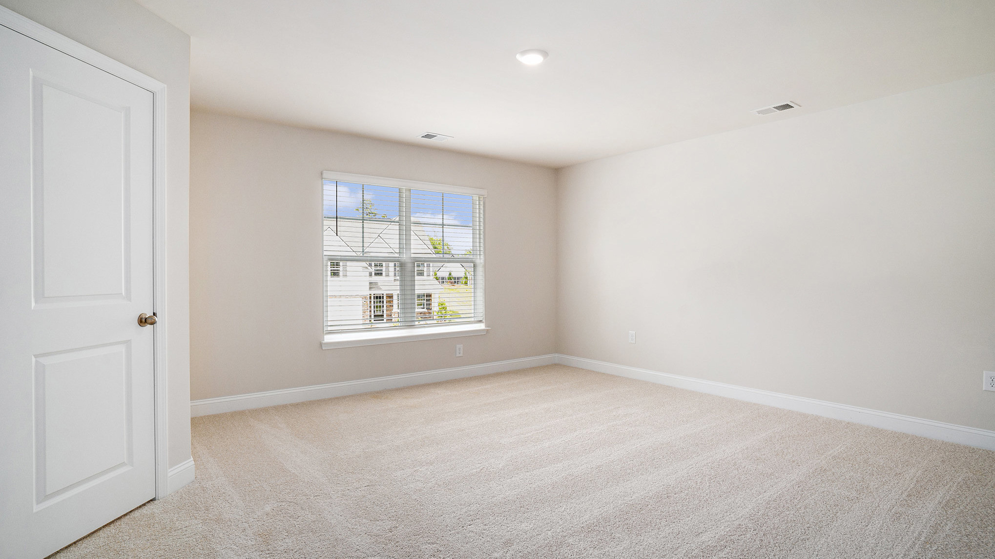 Bedroom 2 with large window and carpet floors