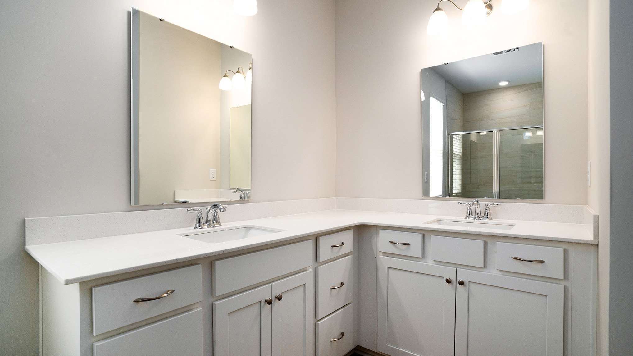 Double primary vanities in the primary bathroom with white quartz countertops