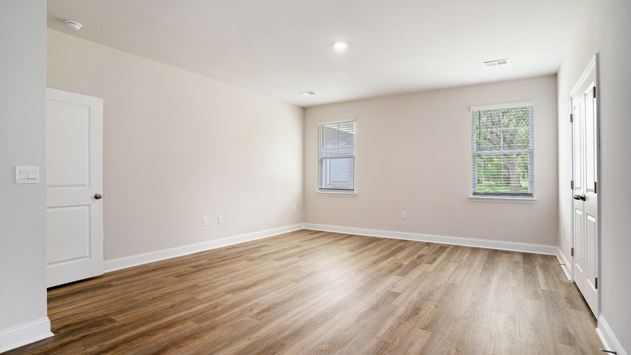 RevWood flooring in the primary bedroom downstairs and 2 windows overlooking the backyard