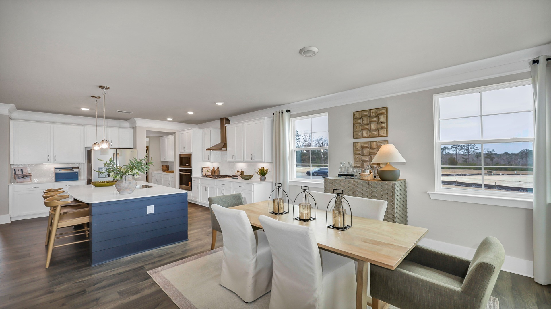 Dining and kitchen areas with windows and neutrally painted walls
