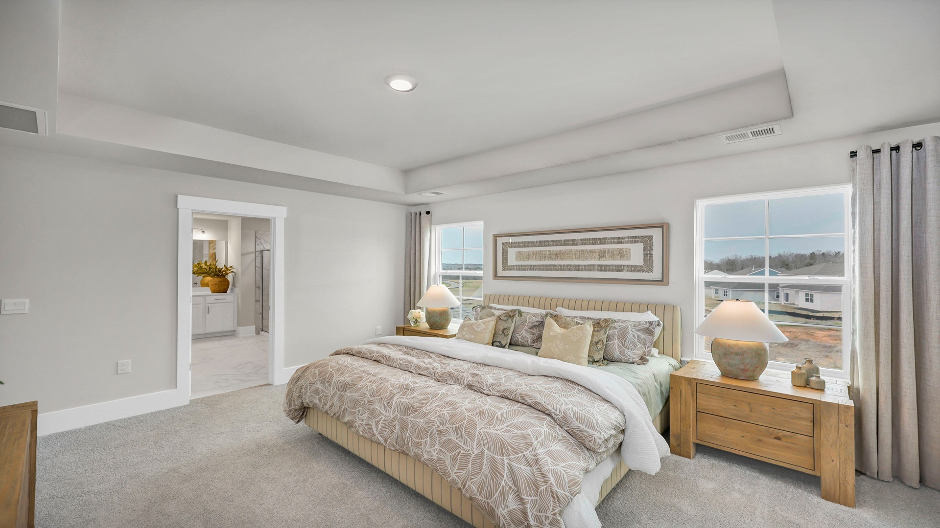 Spacious primary bedroom that comfortably fits a king bed set