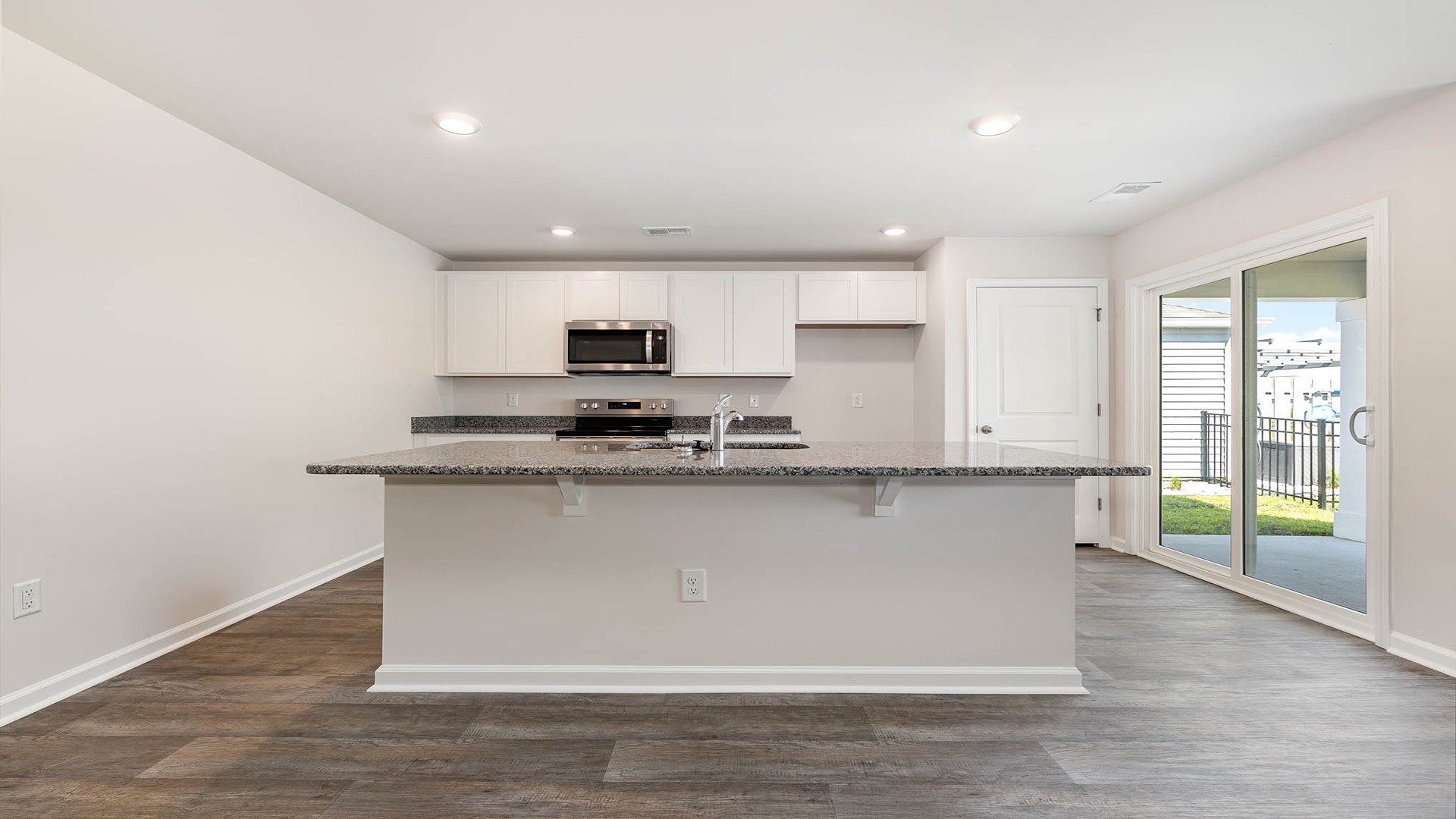 Kerry kitchen with white cabinetry and granite countertops.