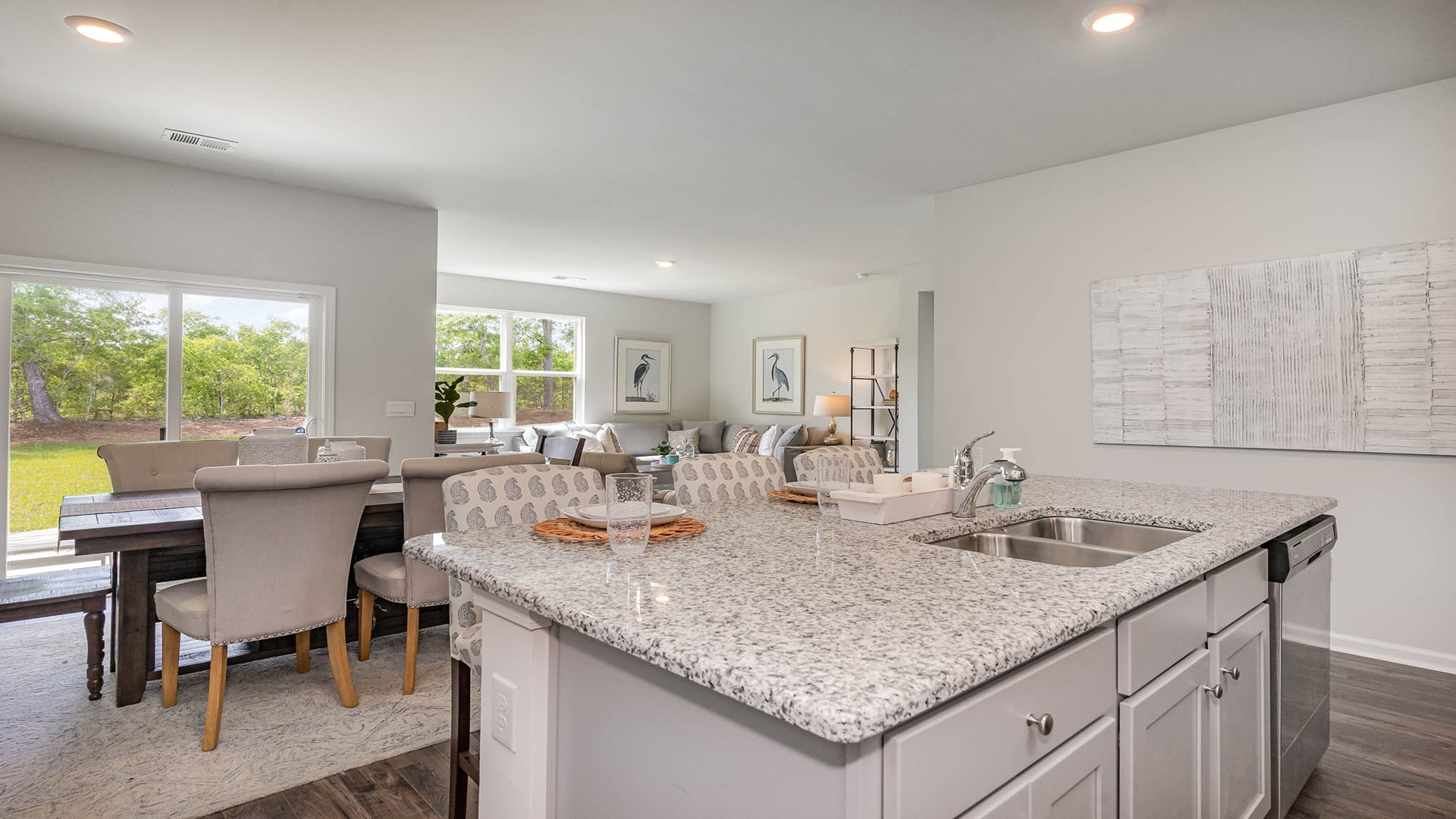 Floating island with kitchen sink overlooking dining and living areas