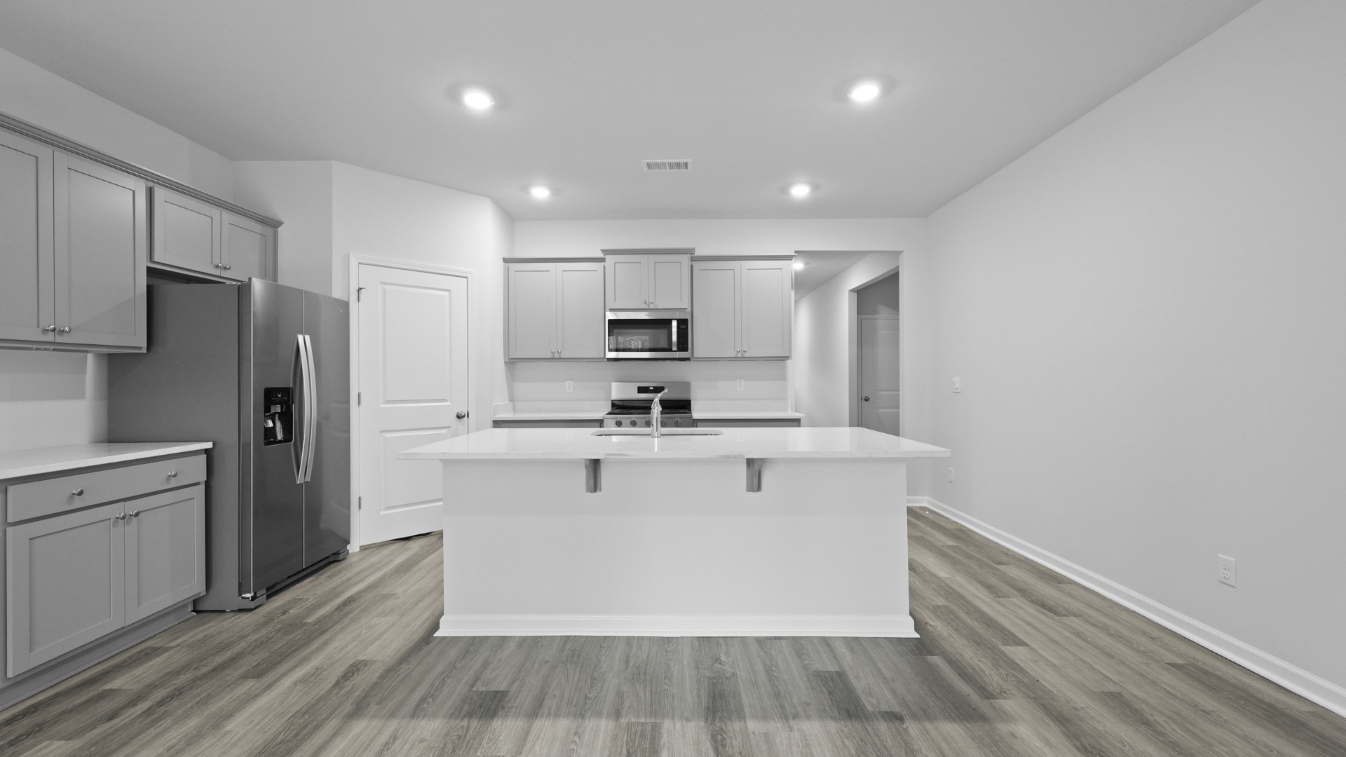 Cali kitchen extends beyond the front foyer and features gray cabinets