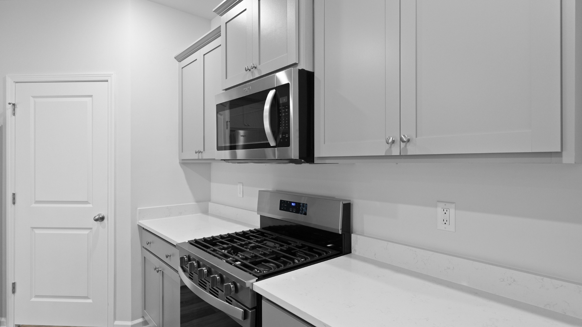 Sleek, quartz countertops finish the kitchen space of the modern kitchen in the Cali in Gates Village