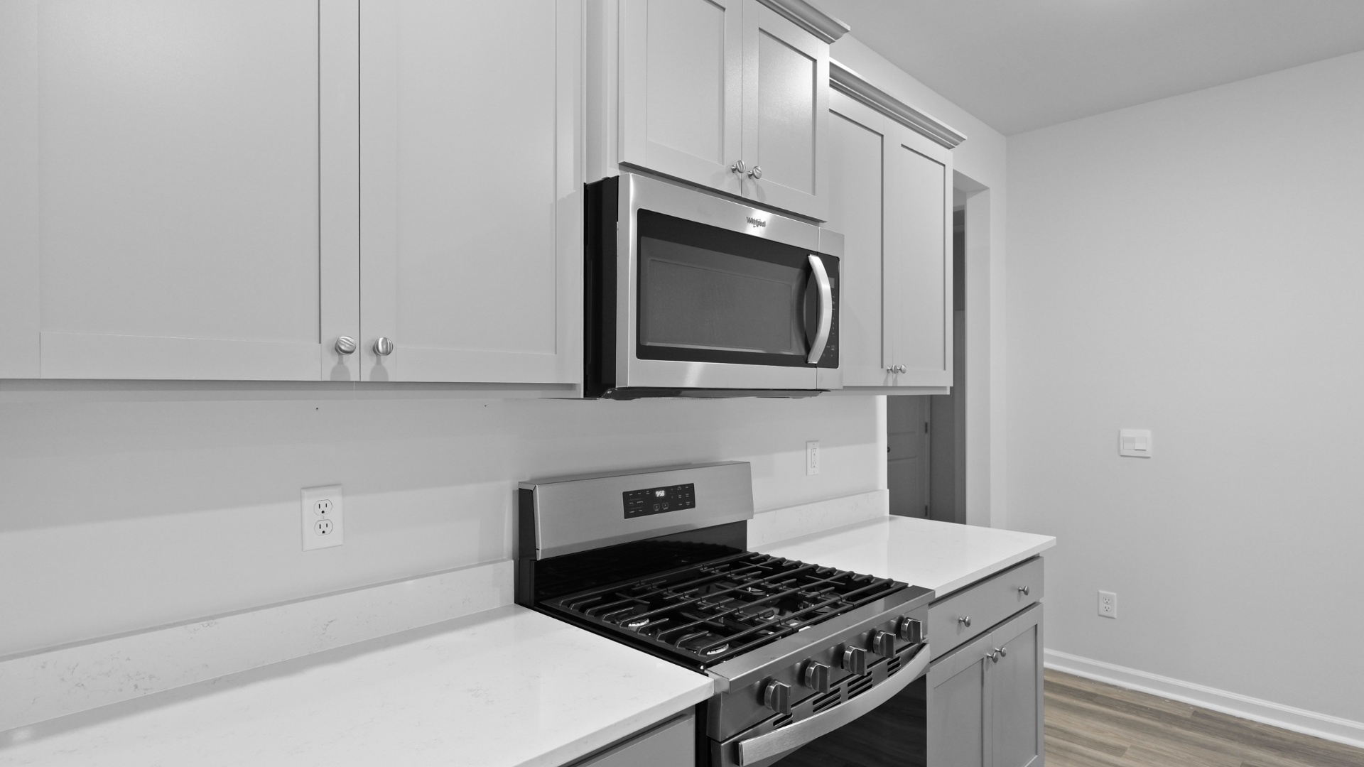 Gray cabinets, stainless-steel appliances, and quartz countertops finish the new construction kitchen