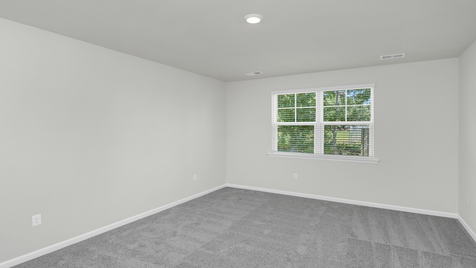 Primary bedroom with window for light and carpet flooring