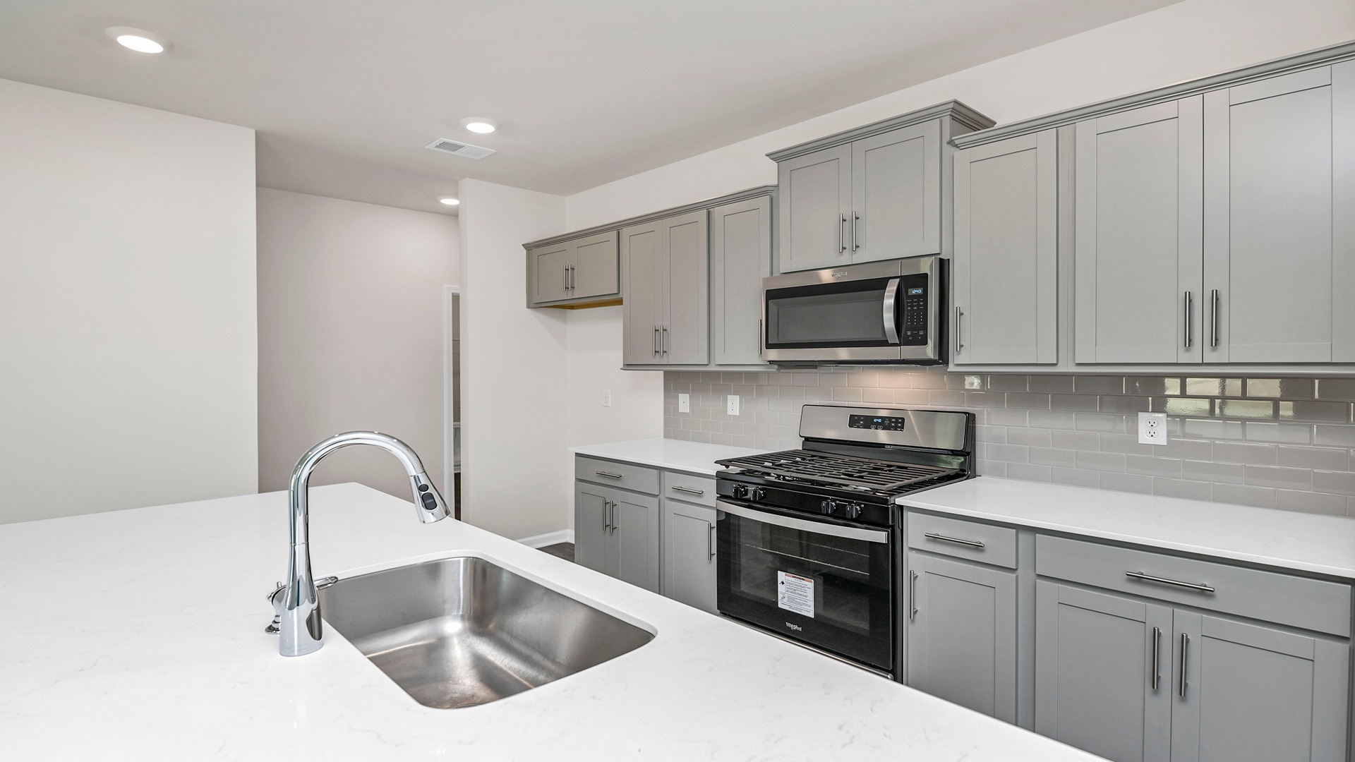White quartz countertops and gray cabinetry in the kitchen