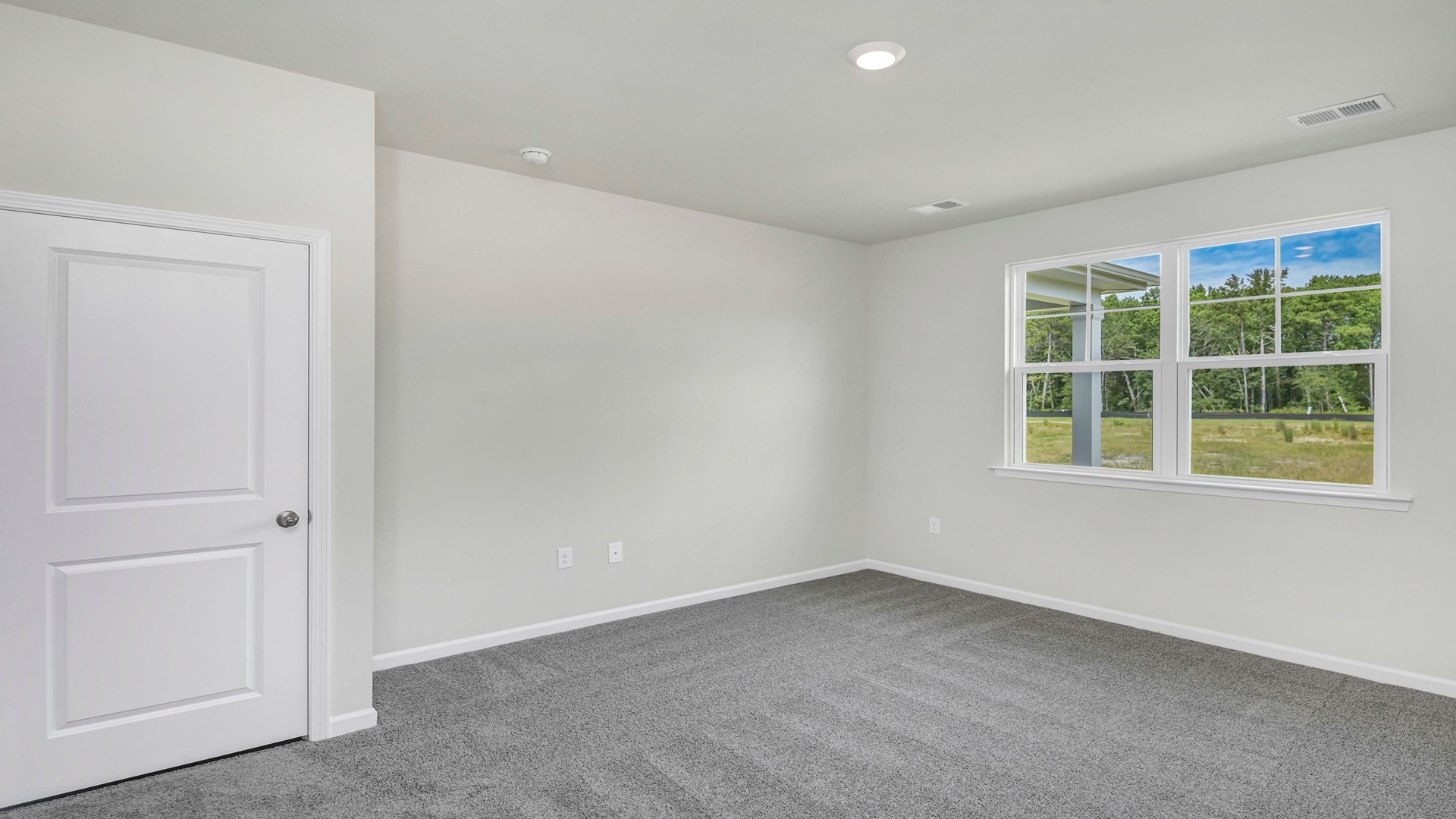 Primary bedroom with a window for natural light and carpet flooring
