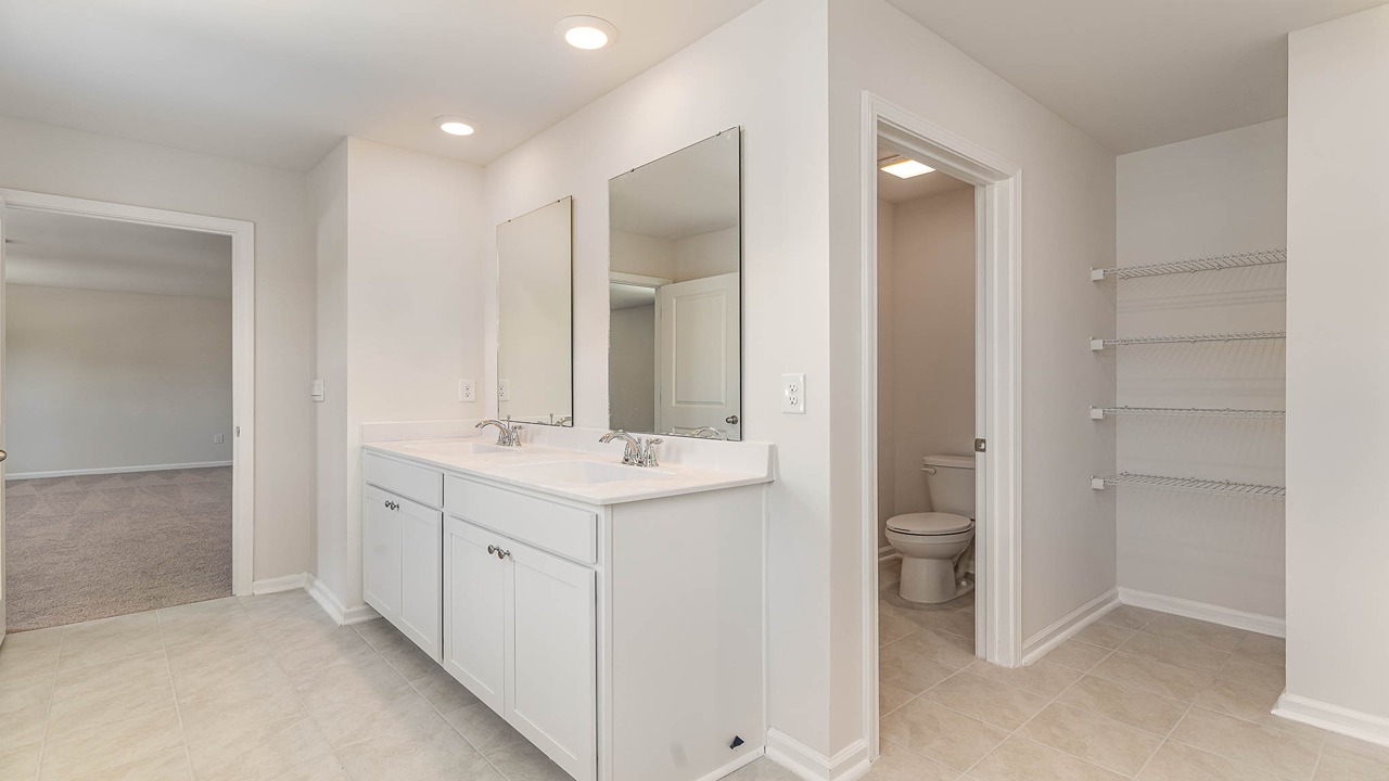 The primary bathroom features double sinks and a standup shower.