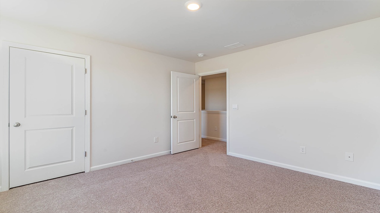 Photos of additional upstairs bedrooms that feature carpet flooring and windows for natural light.
