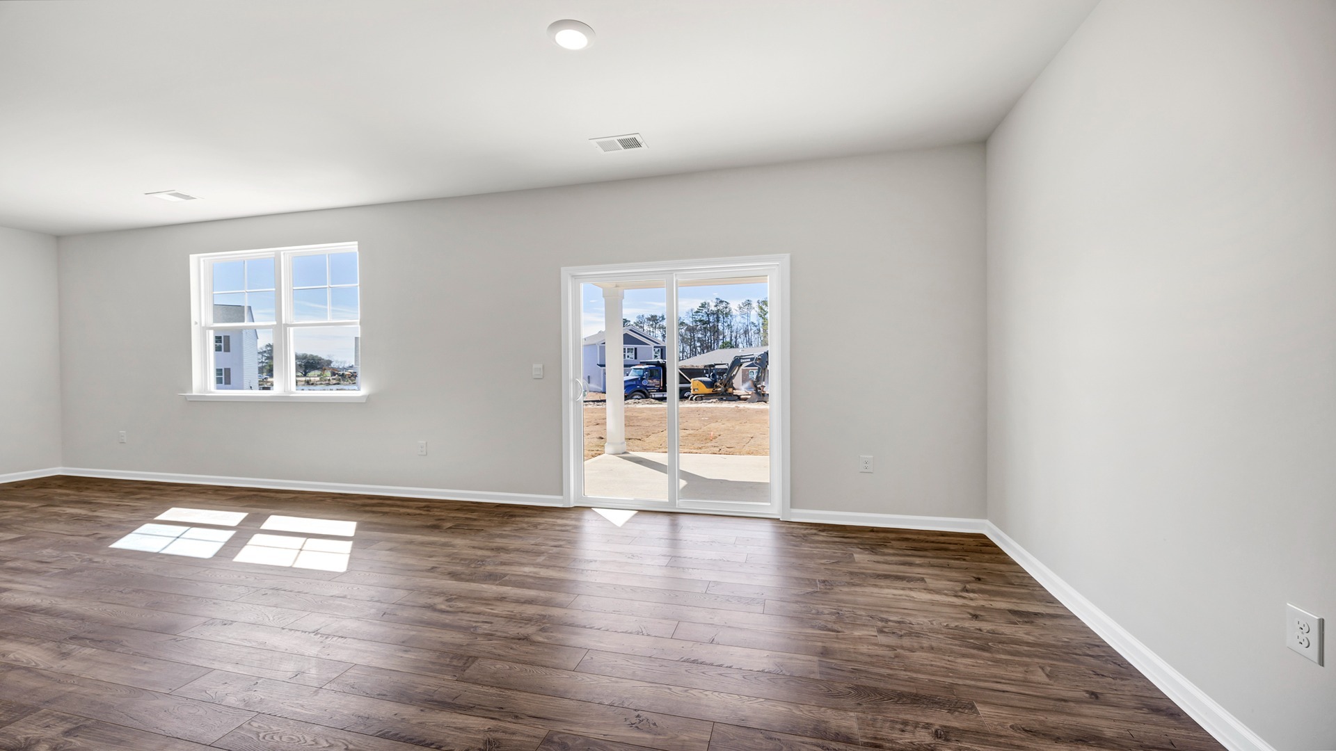 Spacious dining and living areas with matching vinyl floors and natural light