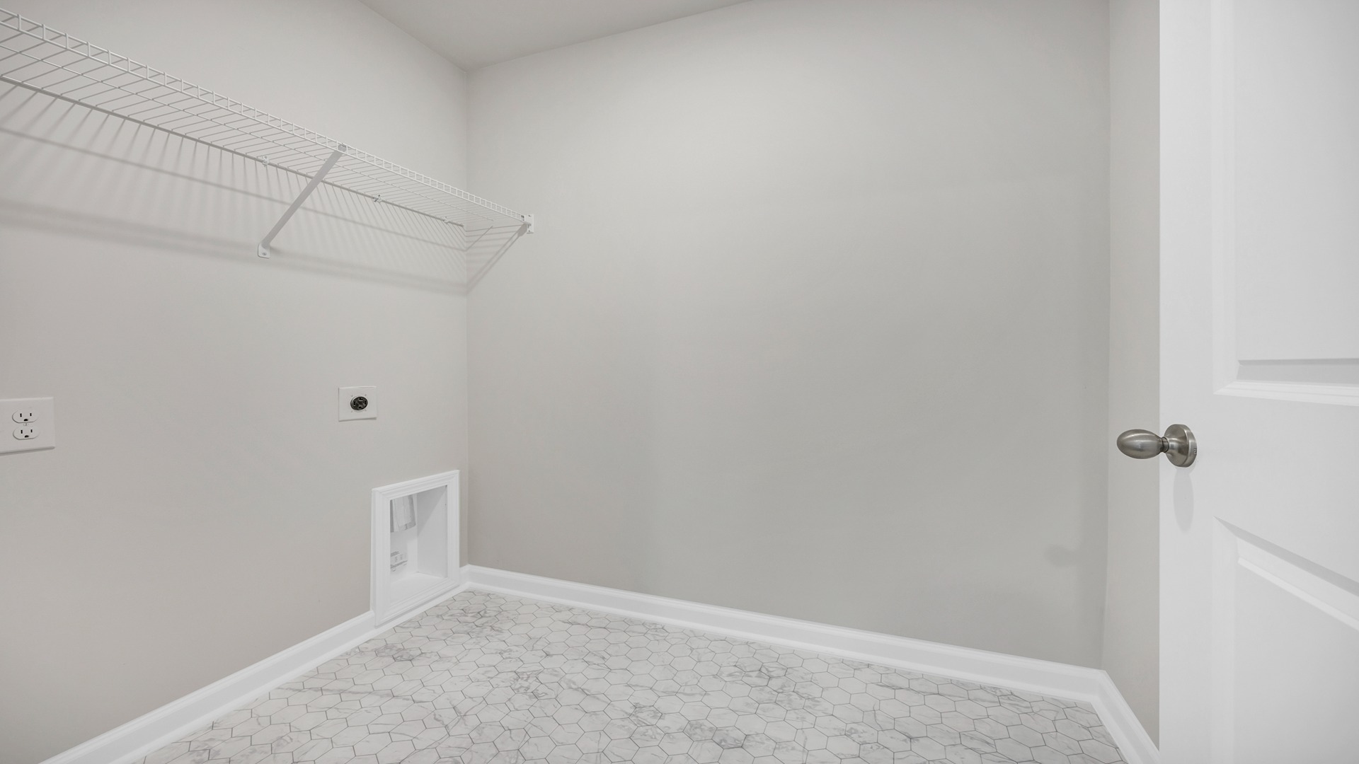 Laundry room upstairs in the two-story Hayden floorplan in Gates Village with wire shelving above