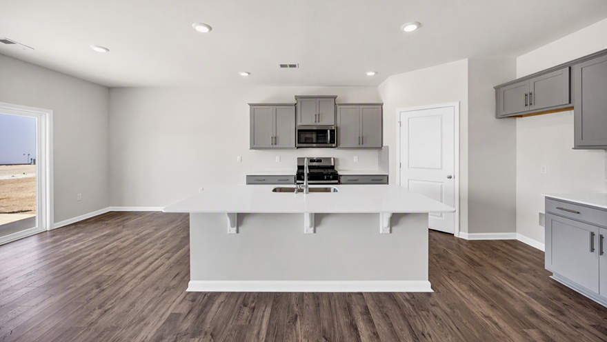 Walk-in corner kitchen pantry in new construction kitchen and space for barstool seating at kitchen island