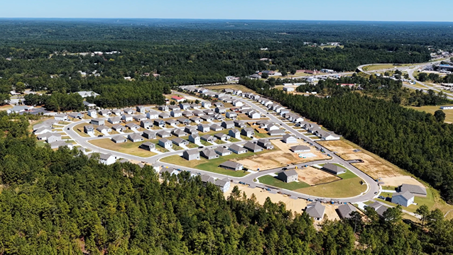 Drone overview of back of community with large sites where new homes are currently being built