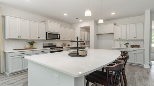 There are sleek quartz countertops in the kitchen.