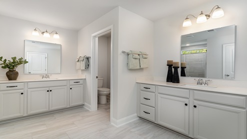 The primary bathroom features two separate vanities.
