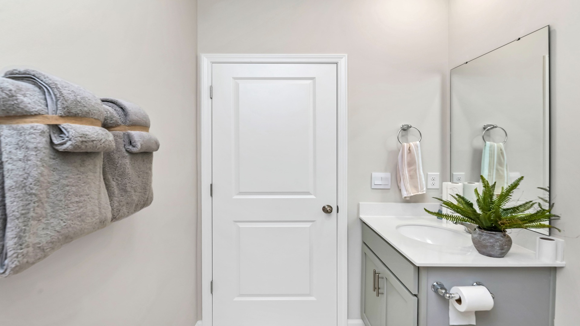 Bathroom 2 features a shower/tub combo and gray cabinetry under the sink.