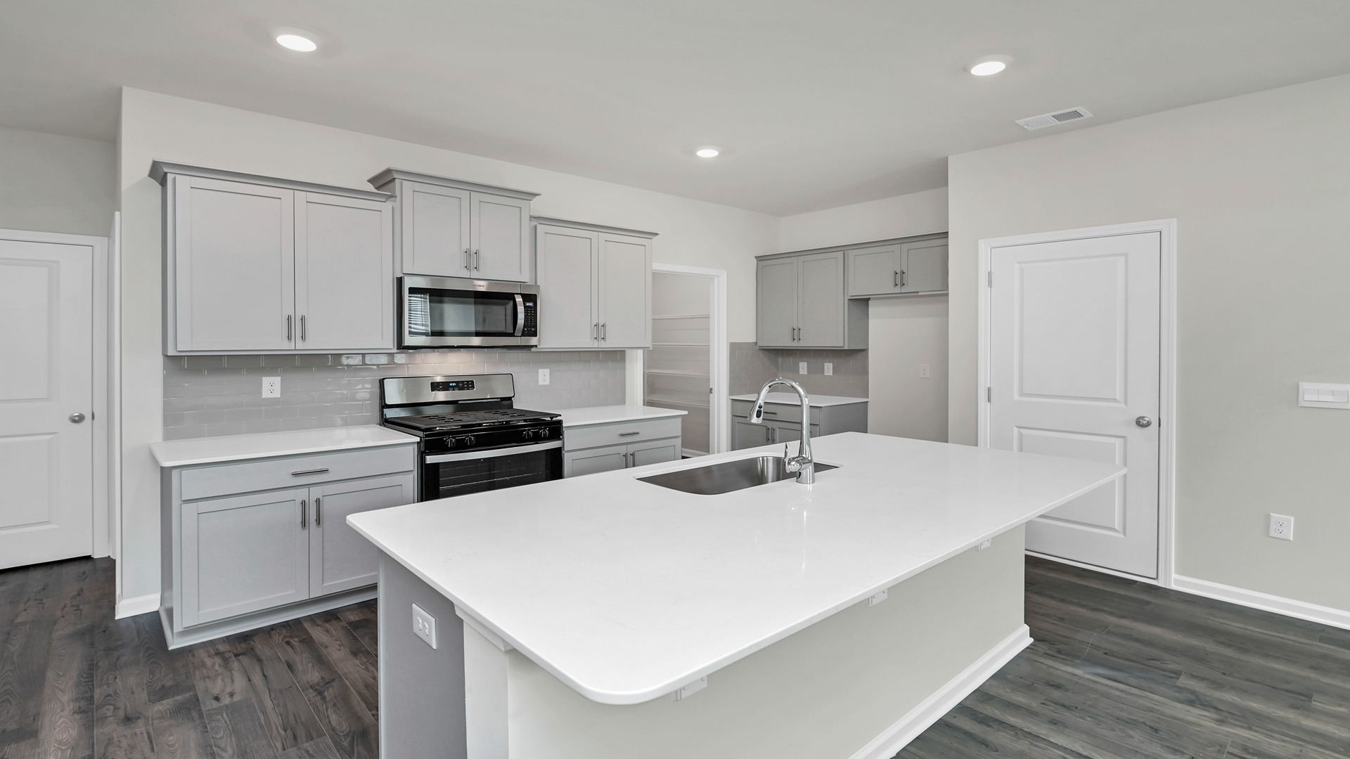The kitchen features white quartz countertops