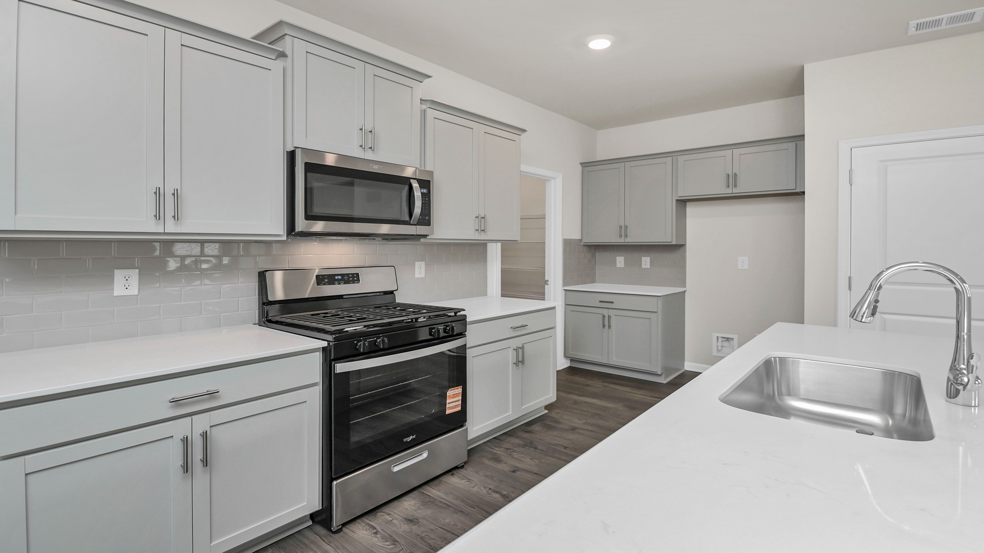 Gray cabinetry and tile backsplash finish the kitchen space