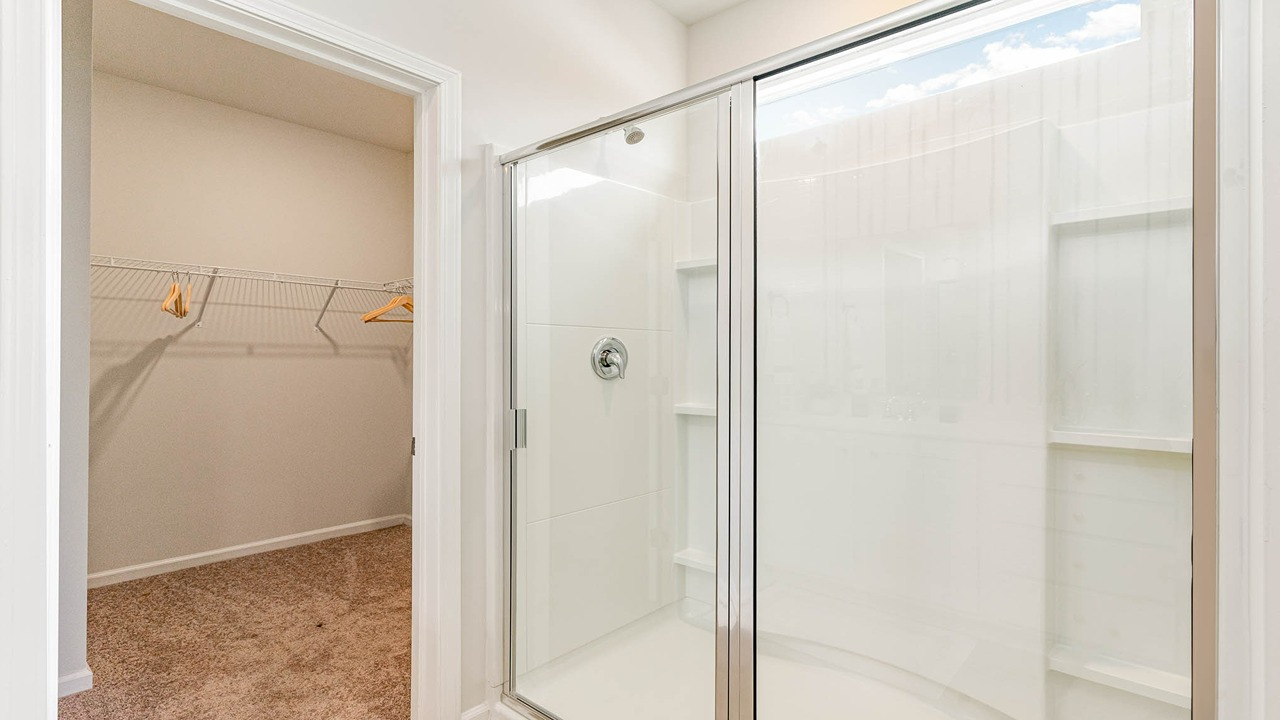 The primary bathroom features a double vanity and a standup shower.