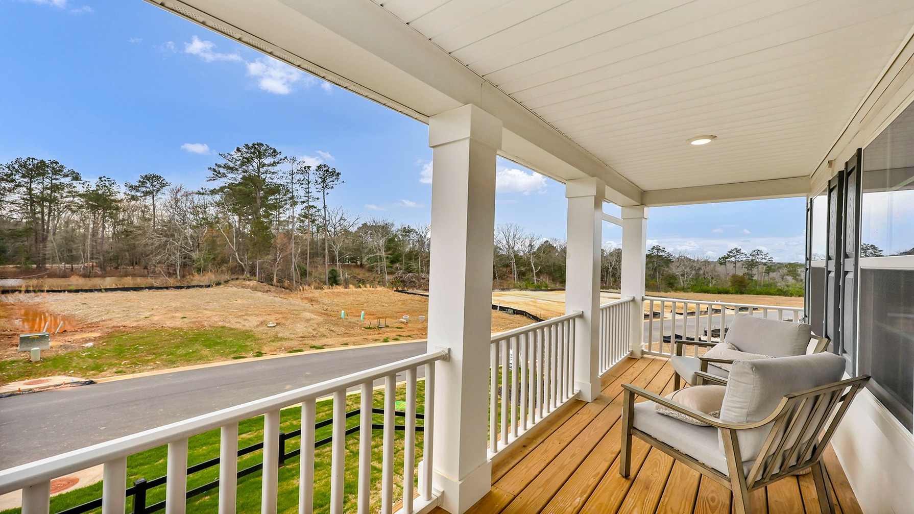 Upstairs balcony with white railing and wood floors