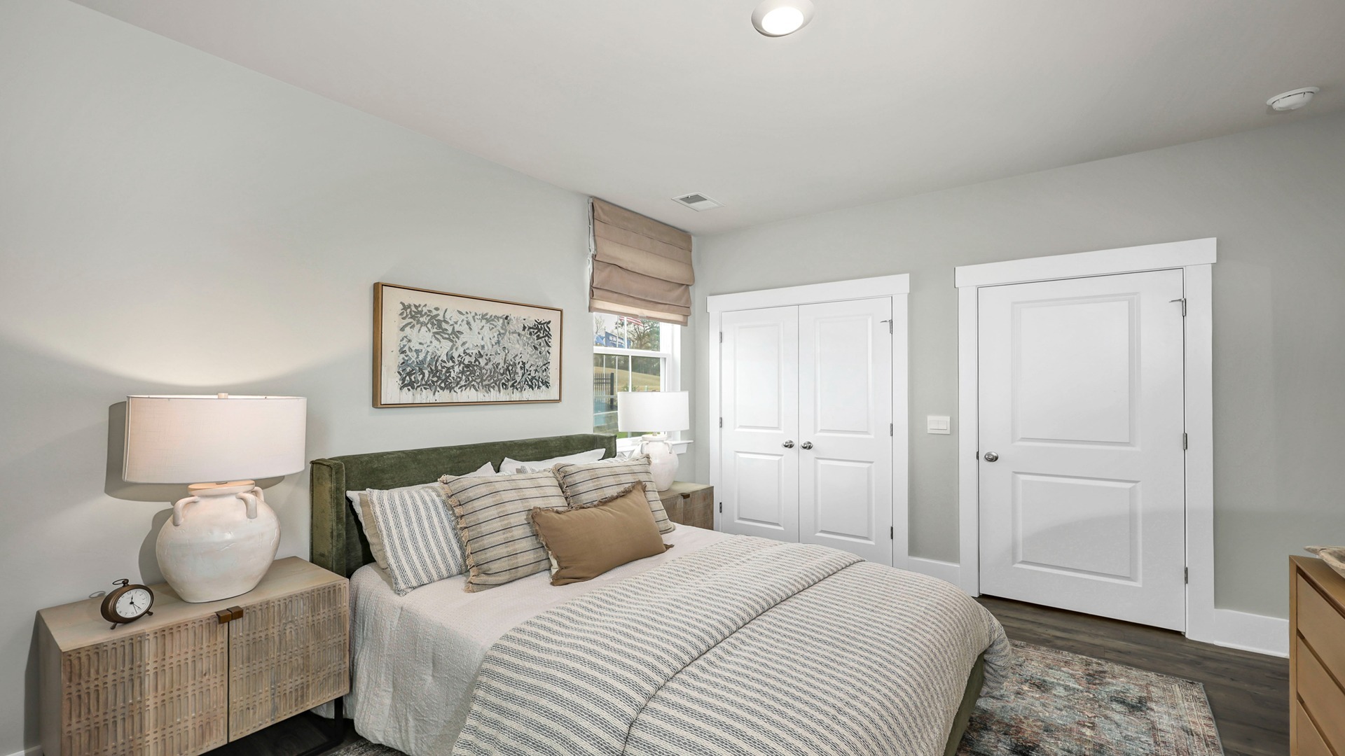 Downstairs bedroom with French closet doors and Revwood flooring