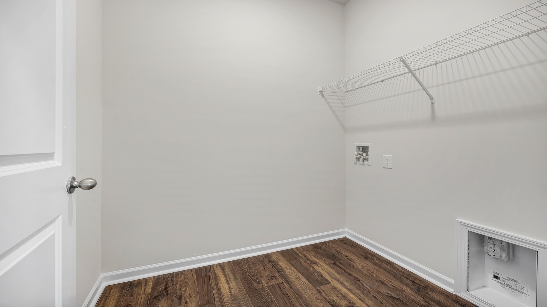 Laundry room with vinyl flooring and shelving above