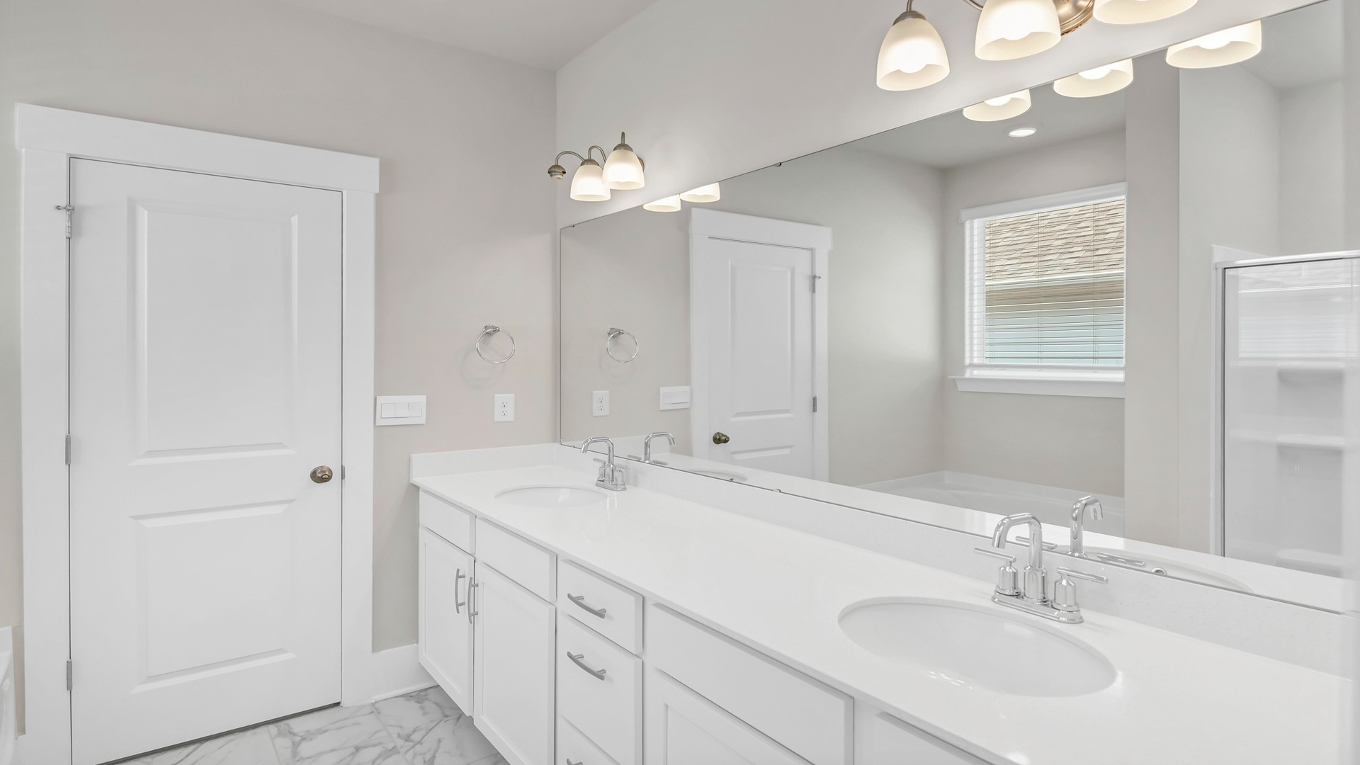 There are double sinks and cabinetry in the primary bathroom.