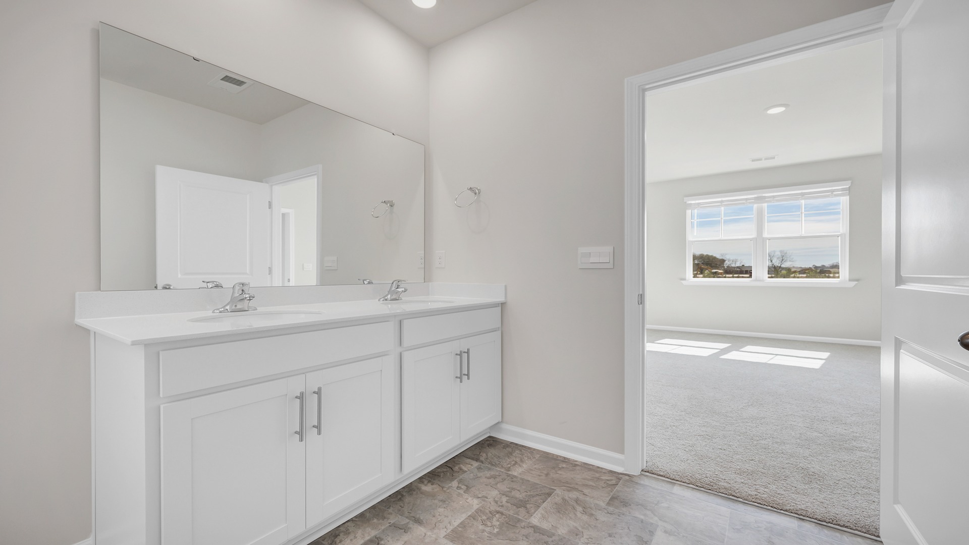 Double primary vanity in the bathroom with quartz countertops and white cabinets